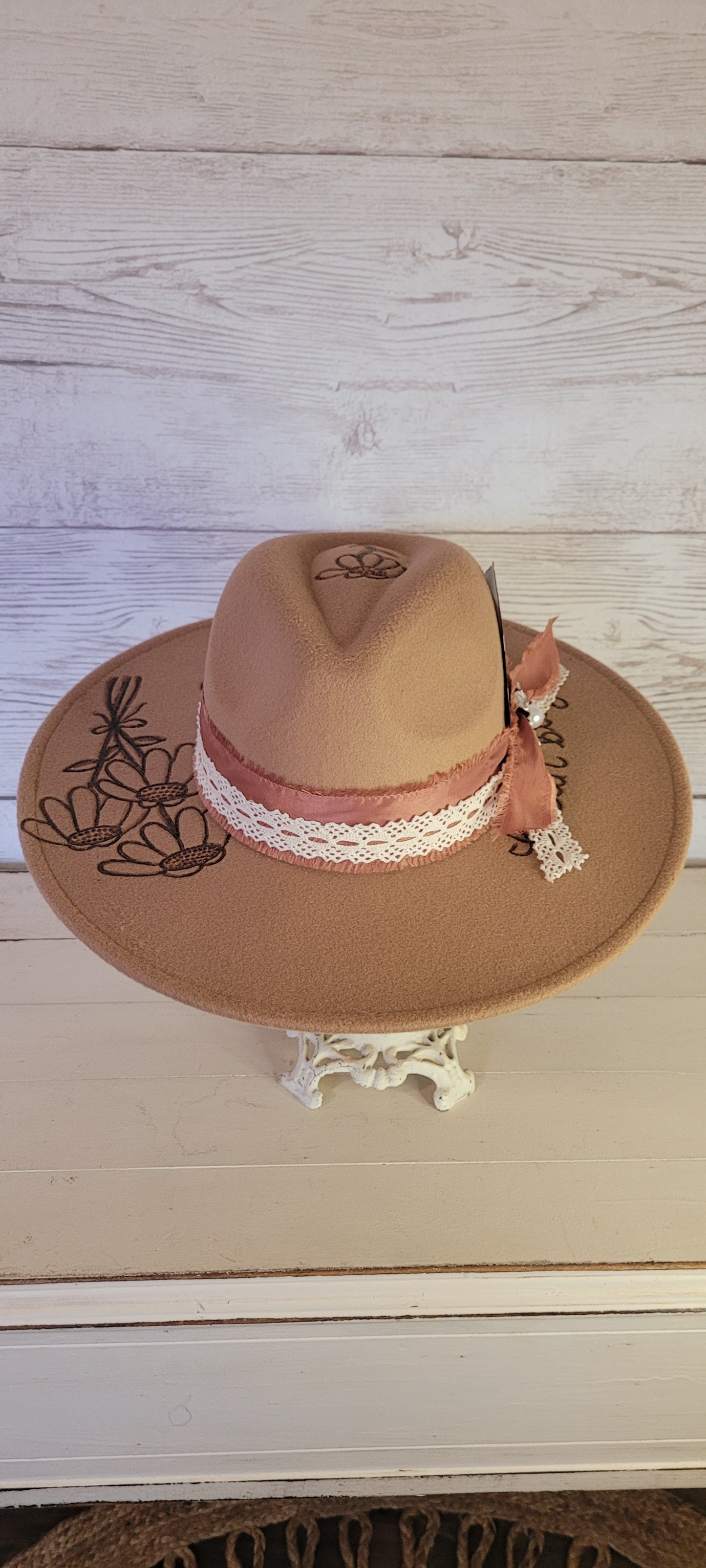 Features "I can by myself flowers" & flowers engraved Frayed rose ribbon, natural lace ribbon with flower brooch & playing card Felt hat Flat brim 65% polyester and 35% cotton Ribbon drawstring for hat size adjustment Head Circumference: 24" Crown Height: 5" Brim Length: 15.75" Brim Width: 14.5" Branded & numbered inside crown Custom burned & engraved by Kayla