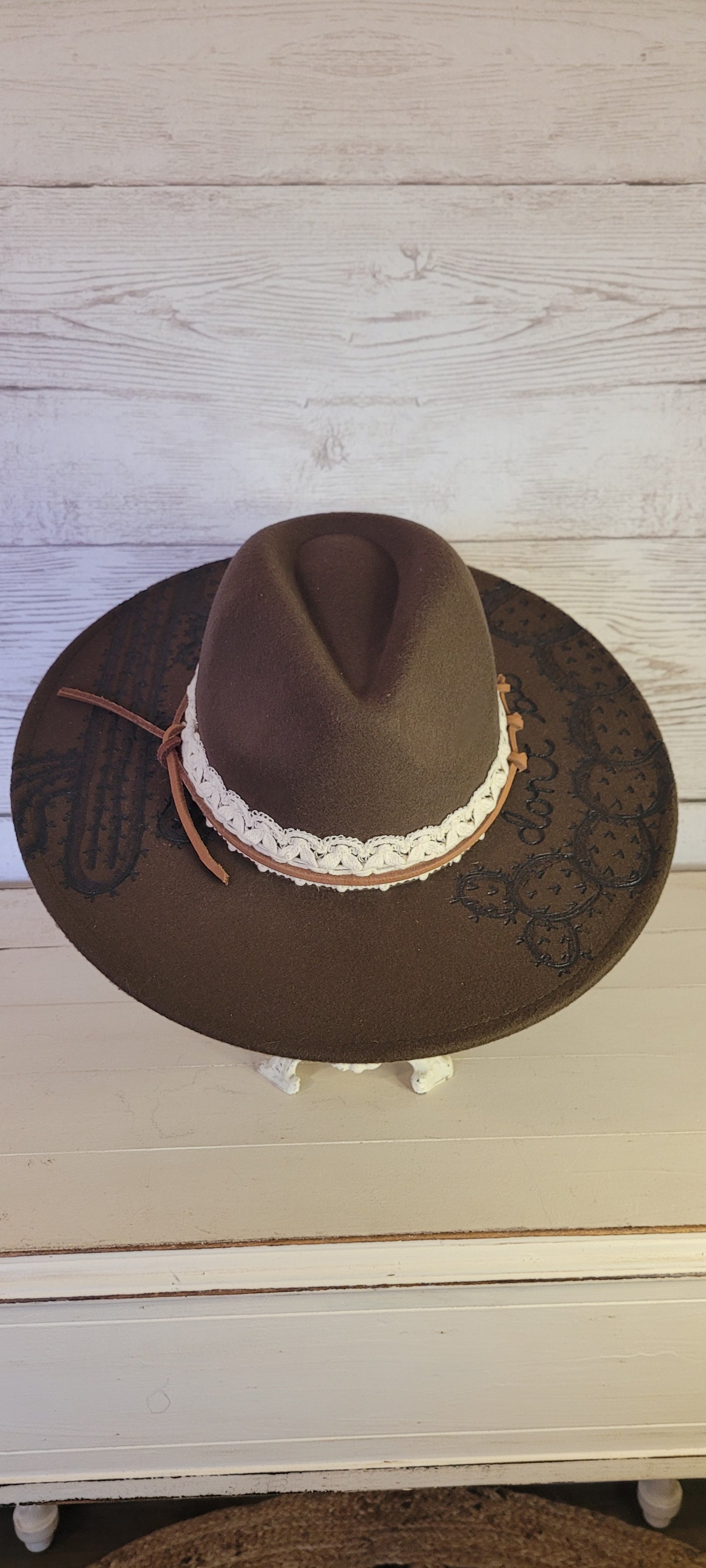 Features "don't be a prick", cactus & saguaro engraving Natural lace ribbon & leather band Felt hat Flat brim 65% polyester and 35% cotton Ribbon drawstring for hat size adjustment Head Circumference: 24" Crown Height: 5" Brim Length: 15.75" Brim Width: 14.5" Branded & numbered inside crown Custom designed by Kayla
