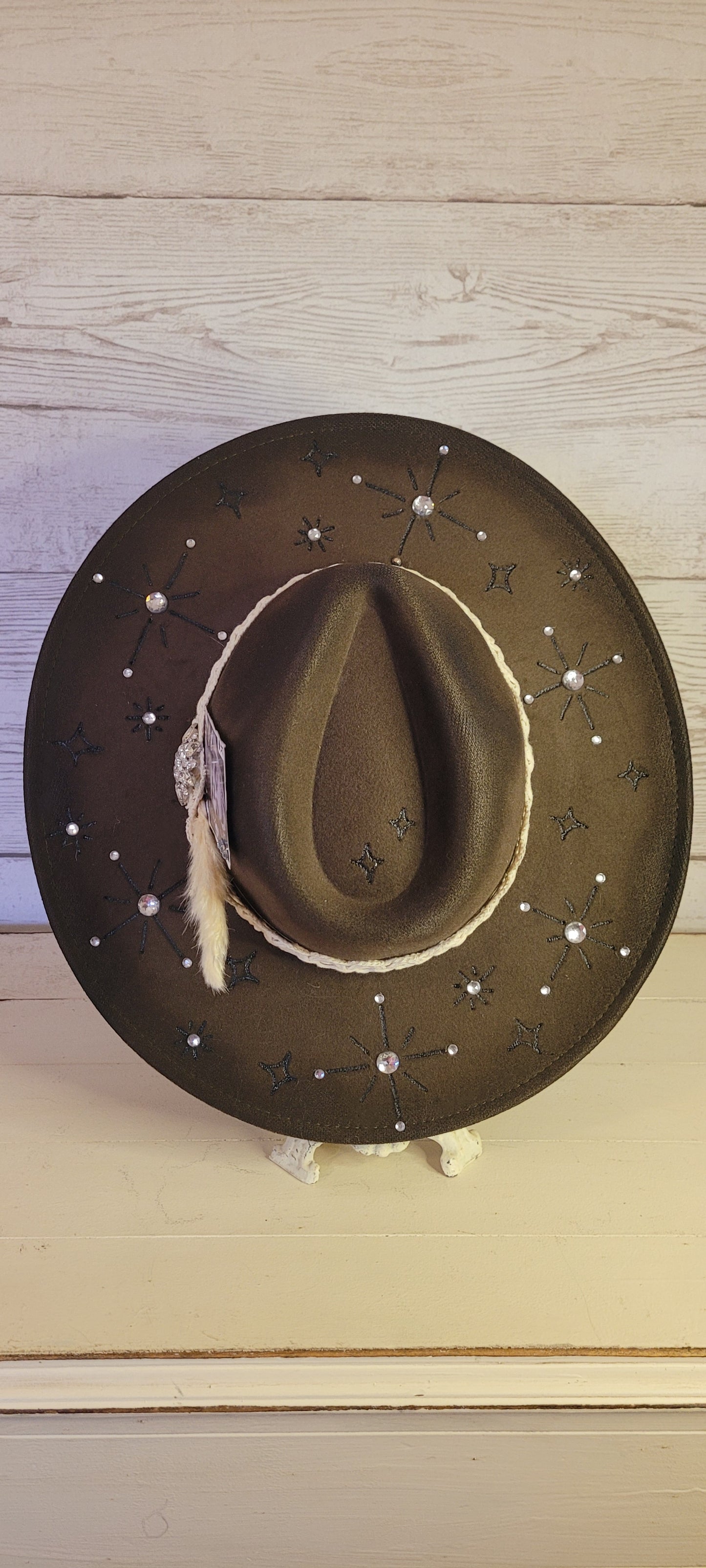 Features engraved stars & diamonds Rhinestone details throughout, pampas, crystal brooch, & playing card Felt hat Flat brim 65% polyester and 35% cotton Ribbon drawstring for hat size adjustment Head Circumference: 24" Crown Height: 5" Brim Length: 15.75" Brim Width: 14.5" Branded & numbered inside crown Custom designed by Kayla
