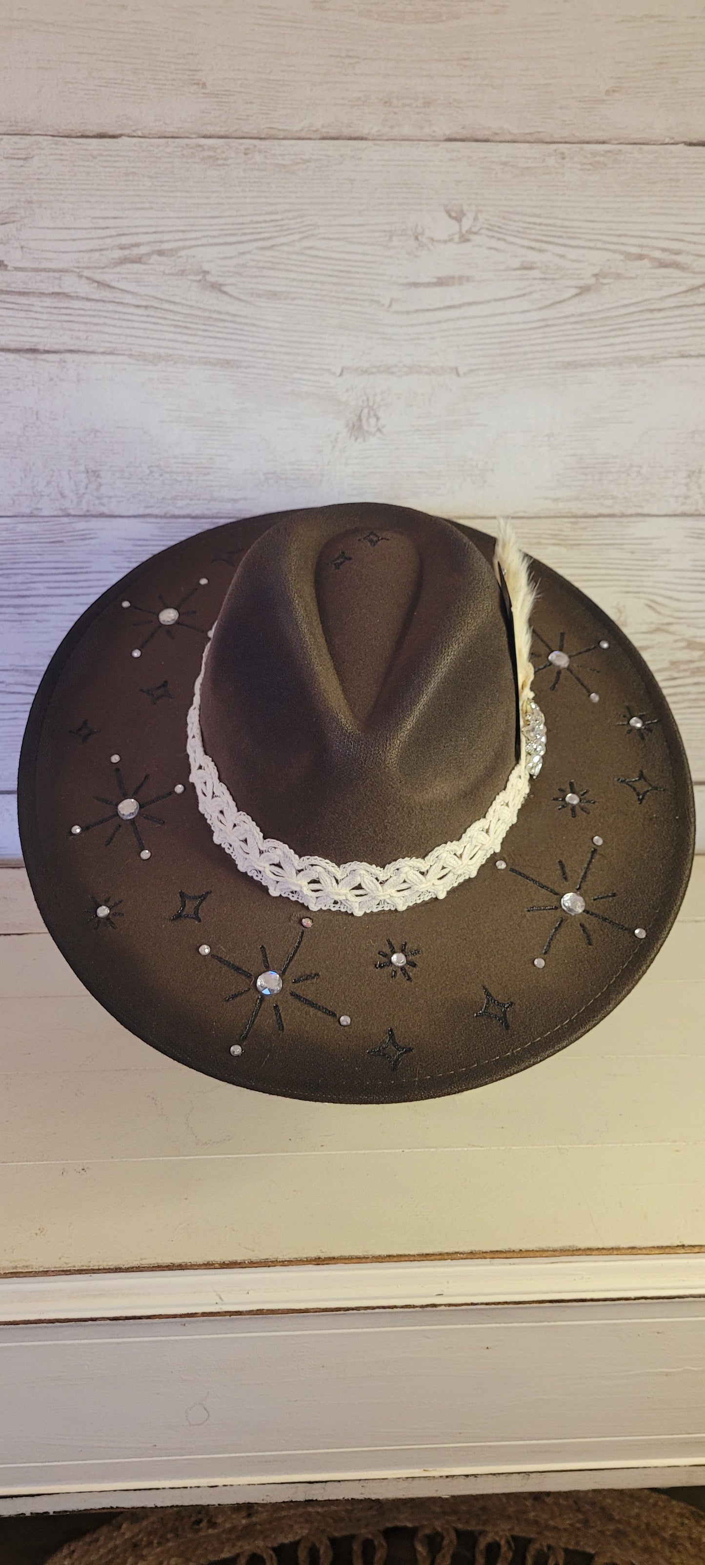 Features engraved stars & diamonds Rhinestone details throughout, pampas, crystal brooch, & playing card Felt hat Flat brim 65% polyester and 35% cotton Ribbon drawstring for hat size adjustment Head Circumference: 24" Crown Height: 5" Brim Length: 15.75" Brim Width: 14.5" Branded & numbered inside crown Custom designed by Kayla