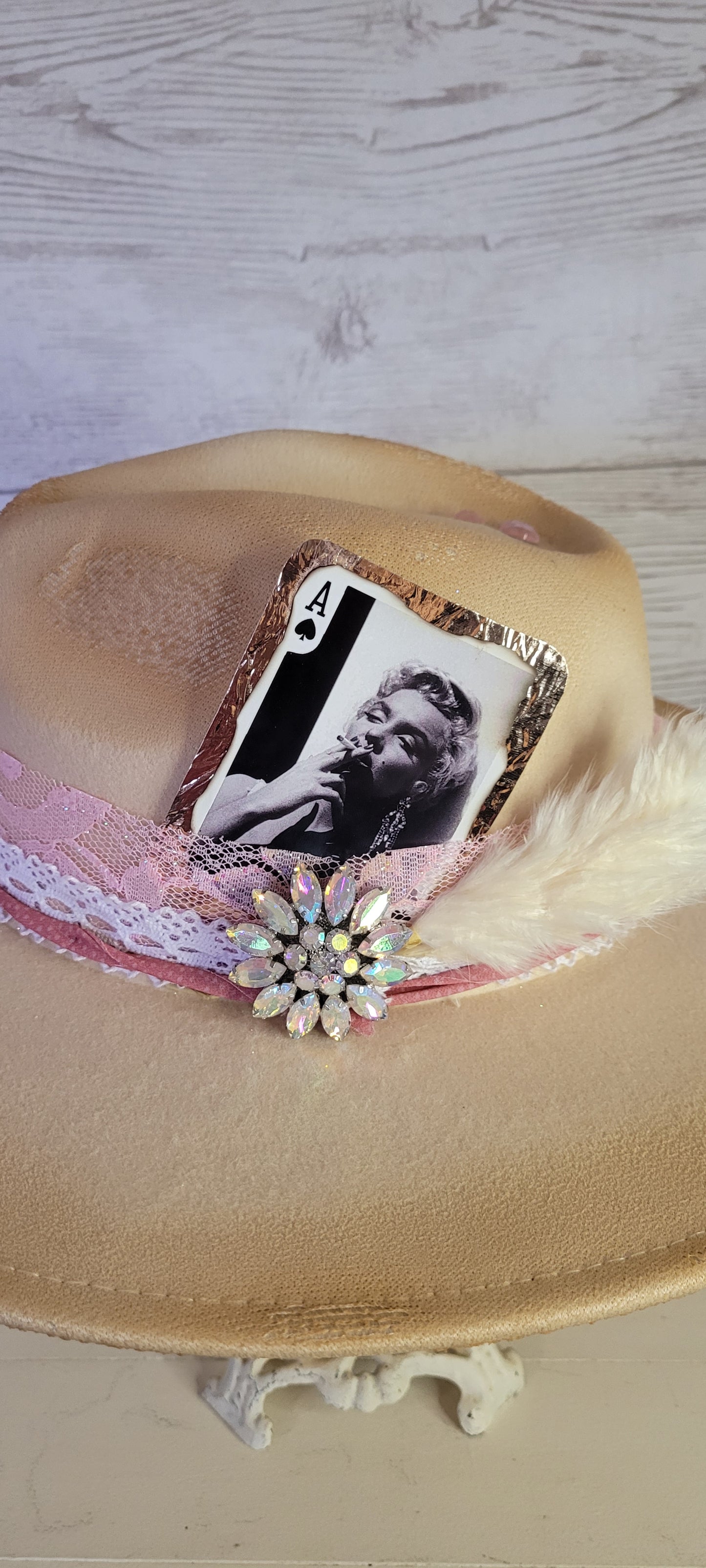 Pink ribbon & lace, natural lace ribbon, pampas, AB rhinestone brooch, light pink rhinestones & playing card Felt hat Flat brim 65% polyester and 35% cotton Ribbon drawstring for hat size adjustment Head Circumference: 24" Crown Height: 5" Brim Length: 15.75" Brim Width: 14.5" Branded & numbered inside crown Custom burned & designed by Kayla