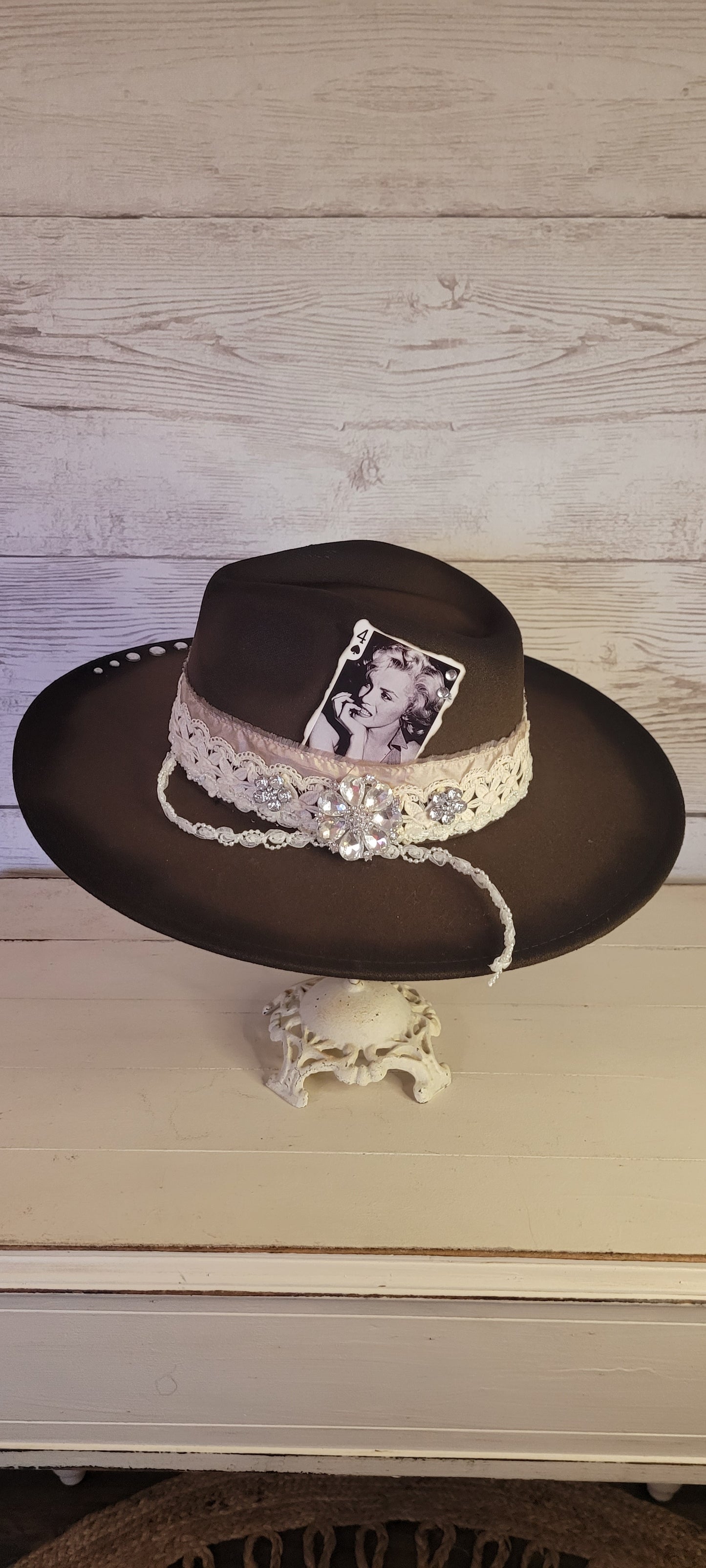 Features rhinestone details on brim, crystal brooches, & playing card, light rose ribbon, natural lace ribbon, pearl ribbon Felt hat Flat brim 65% polyester and 35% cotton Ribbon drawstring for hat size adjustment Head Circumference: 24" Crown Height: 5" Brim Length: 15.75" Brim Width: 14.5" Branded & numbered inside crown Custom designed by Kayla