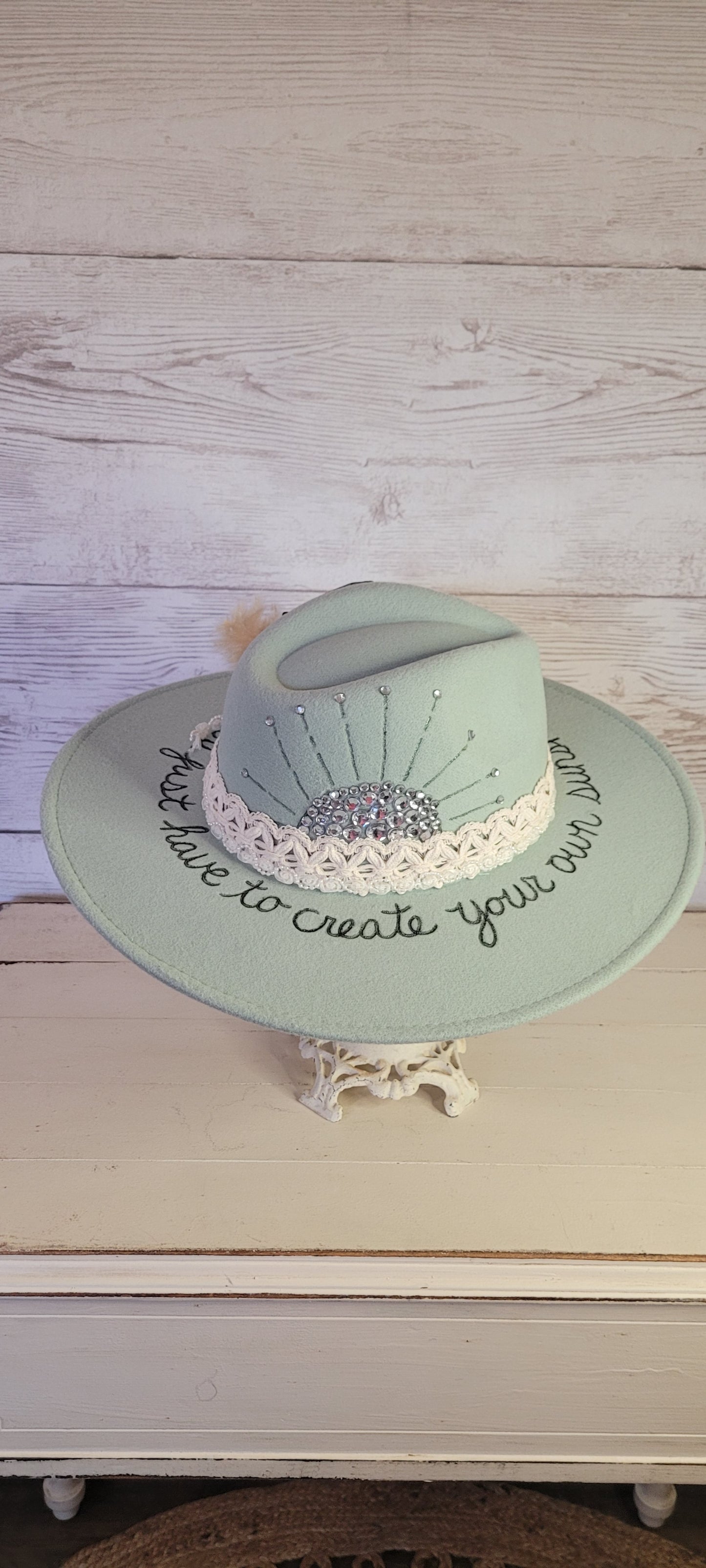 Features sunshine & "somedays you just have to create your own sunshine" engraved Natural lace ribbon, pearl lace ribbon, pampas, playing card with rhinestones Felt hat Flat brim 65% polyester and 35% cotton Ribbon drawstring for hat size adjustment Head Circumference: 24" Crown Height: 5" Brim Length: 15.75" Brim Width: 14.5" Branded & numbered inside crown Custom burned & engraved by Kayla