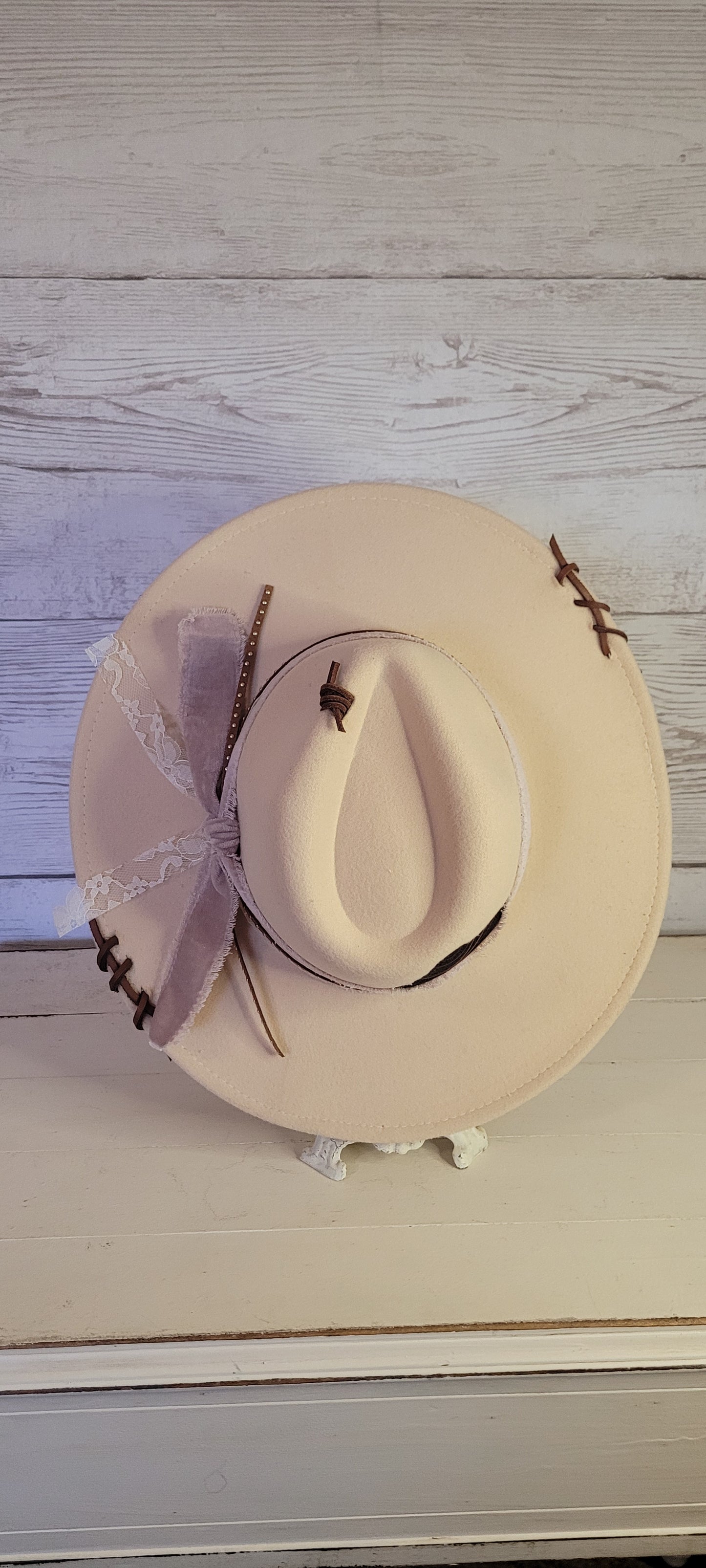 Features velvet mushroom ribbon, lace ribbon, leather band with metal detailing, & leather sewn into brim & crown Felt hat Flat brim 65% polyester and 35% cotton Ribbon drawstring for hat size adjustment Head Circumference: 24" Crown Height: 5" Brim Length: 15.75" Brim Width: 14.5" Branded & numbered inside crown Custom designed by Kayla