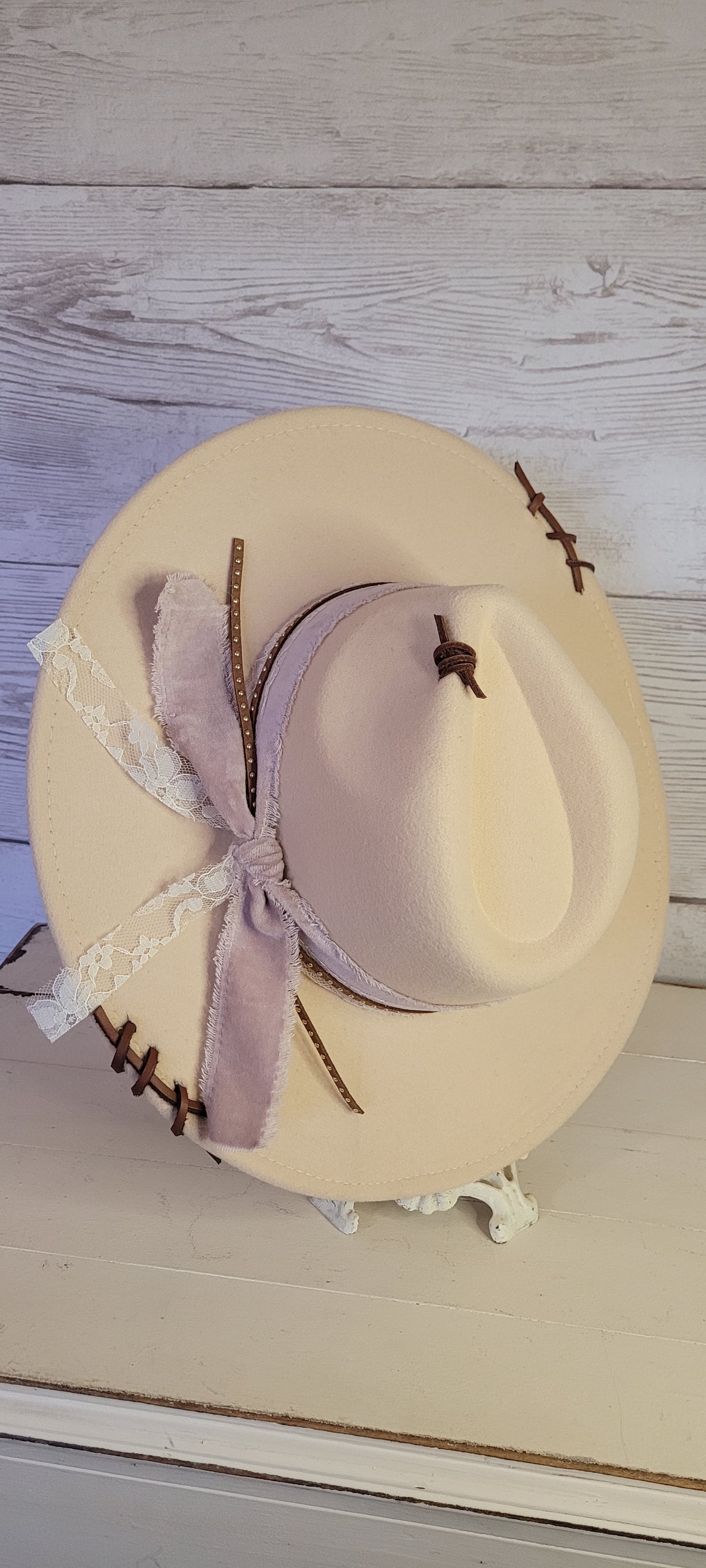 Features velvet mushroom ribbon, lace ribbon, leather band with metal detailing, & leather sewn into brim & crown Felt hat Flat brim 65% polyester and 35% cotton Ribbon drawstring for hat size adjustment Head Circumference: 24" Crown Height: 5" Brim Length: 15.75" Brim Width: 14.5" Branded & numbered inside crown Custom designed by Kayla