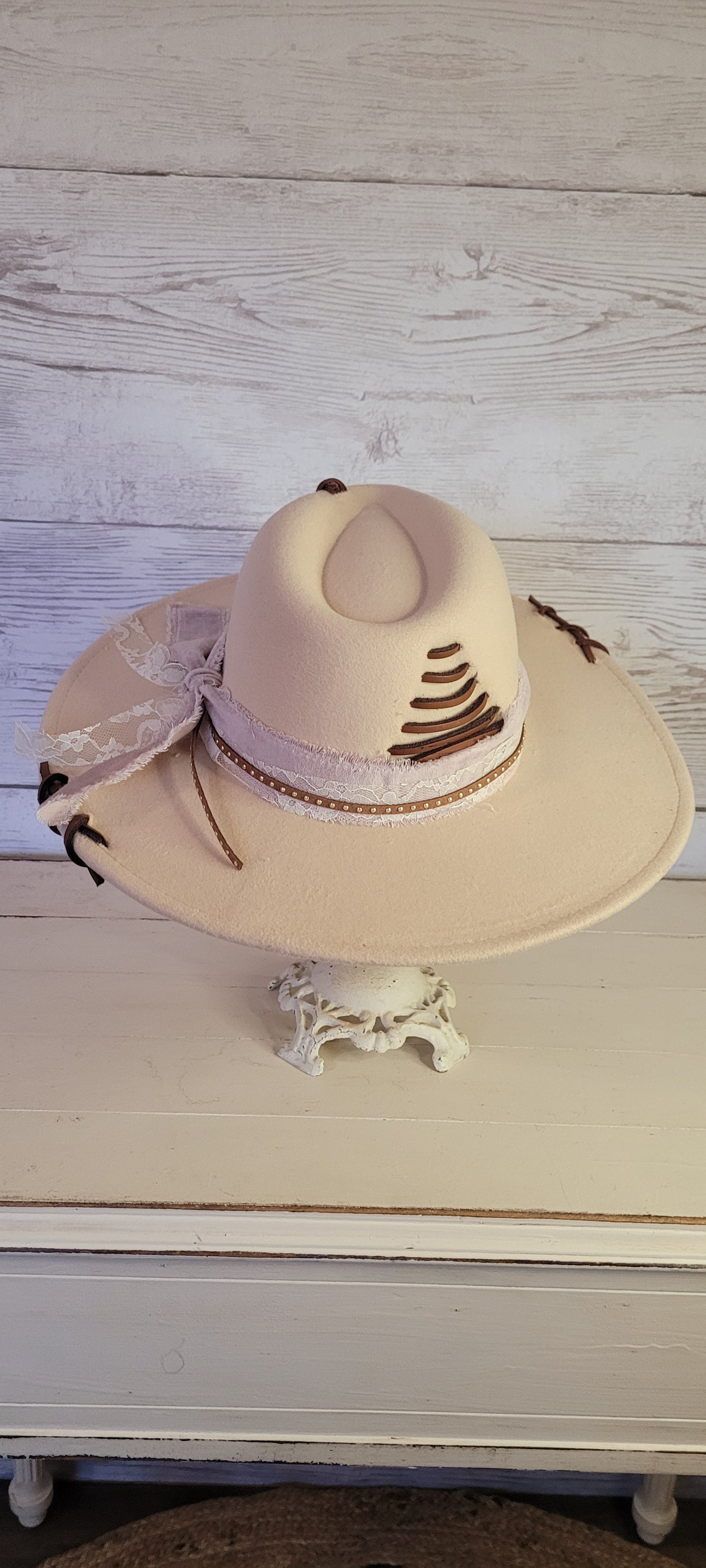 Features velvet mushroom ribbon, lace ribbon, leather band with metal detailing, & leather sewn into brim & crown Felt hat Flat brim 65% polyester and 35% cotton Ribbon drawstring for hat size adjustment Head Circumference: 24" Crown Height: 5" Brim Length: 15.75" Brim Width: 14.5" Branded & numbered inside crown Custom designed by Kayla