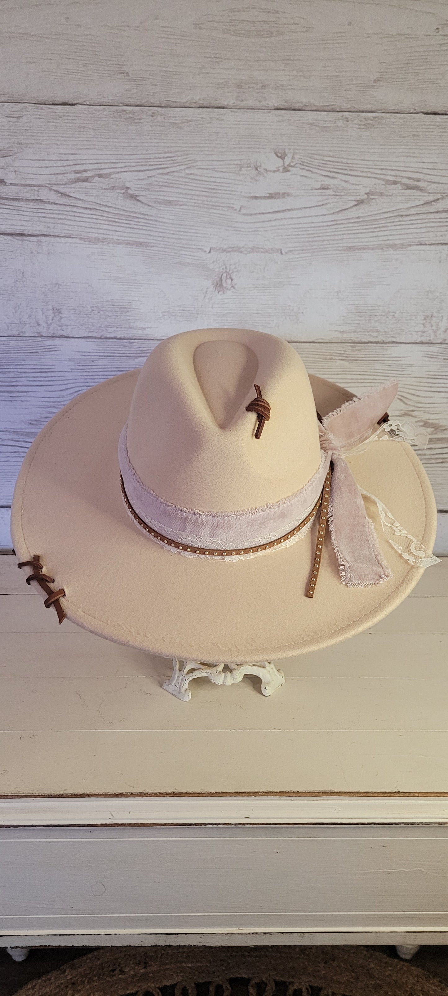 Features velvet mushroom ribbon, lace ribbon, leather band with metal detailing, & leather sewn into brim & crown Felt hat Flat brim 65% polyester and 35% cotton Ribbon drawstring for hat size adjustment Head Circumference: 24" Crown Height: 5" Brim Length: 15.75" Brim Width: 14.5" Branded & numbered inside crown Custom designed by Kayla