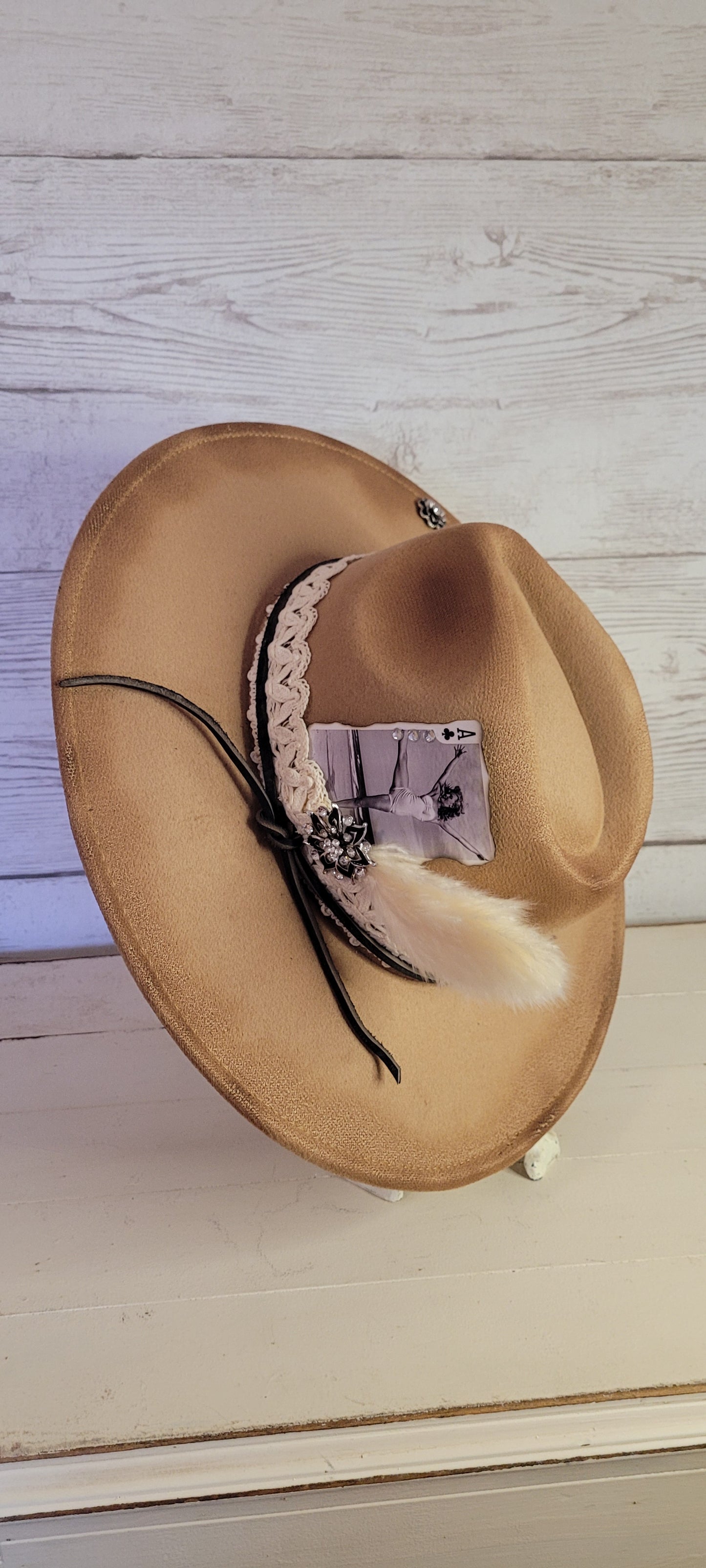 Features "I'm acting up" engraving Lace ribbon, leather band, pampas, rhinestone brooches, playing card Felt hat Flat brim 100% polyester Ribbon drawstring for hat size adjustment Head Circumference: 24" Crown Height: 5" Brim Length: 15.75" Brim Width: 14.5" Branded & numbered inside crown Custom burned & engraved by Kayla