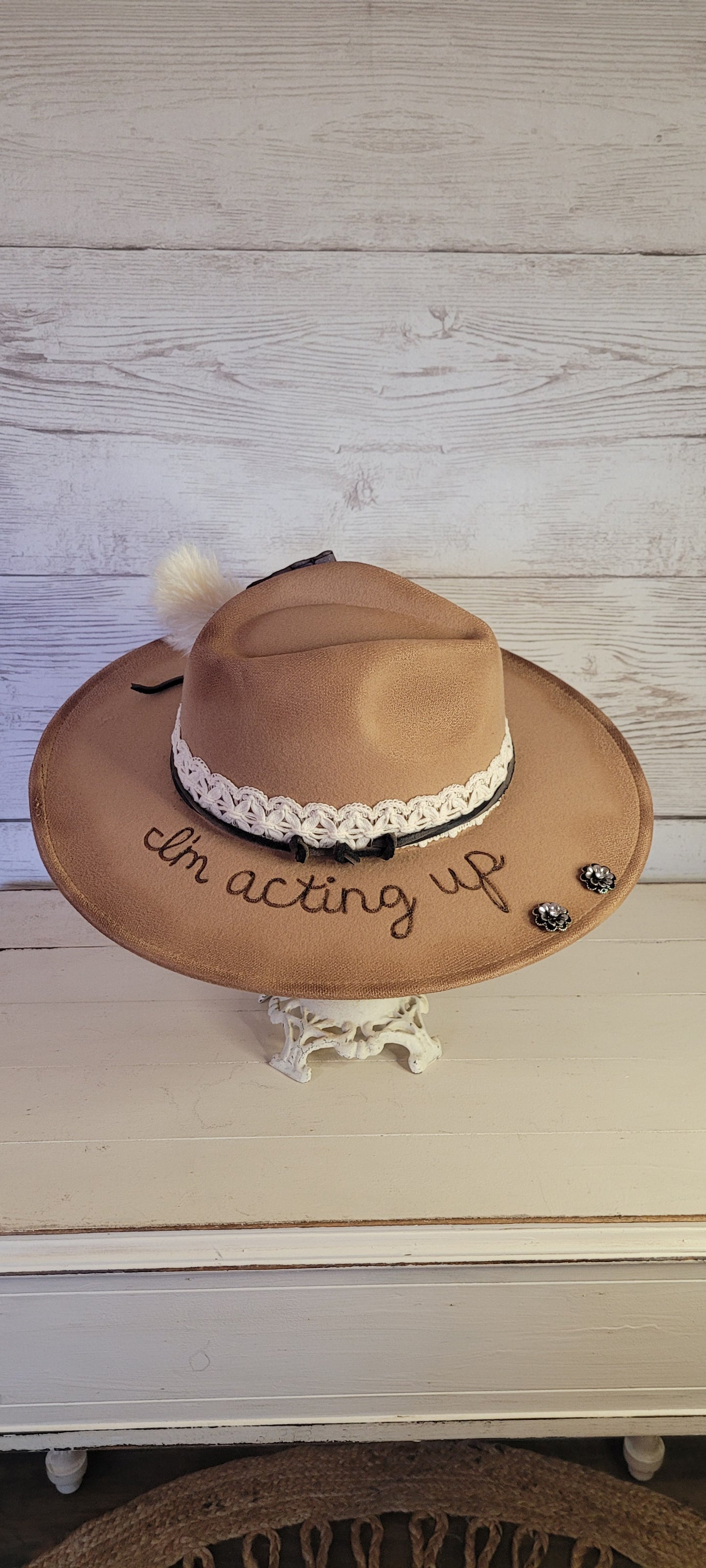 Features "I'm acting up" engraving Lace ribbon, leather band, pampas, rhinestone brooches, playing card Felt hat Flat brim 100% polyester Ribbon drawstring for hat size adjustment Head Circumference: 24" Crown Height: 5" Brim Length: 15.75" Brim Width: 14.5" Branded & numbered inside crown Custom burned & engraved by Kayla
