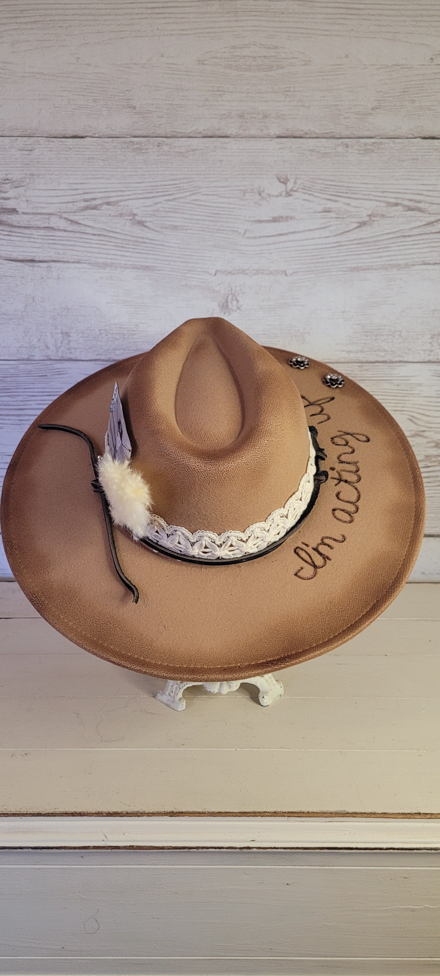 Features "I'm acting up" engraving Lace ribbon, leather band, pampas, rhinestone brooches, playing card Felt hat Flat brim 100% polyester Ribbon drawstring for hat size adjustment Head Circumference: 24" Crown Height: 5" Brim Length: 15.75" Brim Width: 14.5" Branded & numbered inside crown Custom burned & engraved by Kayla