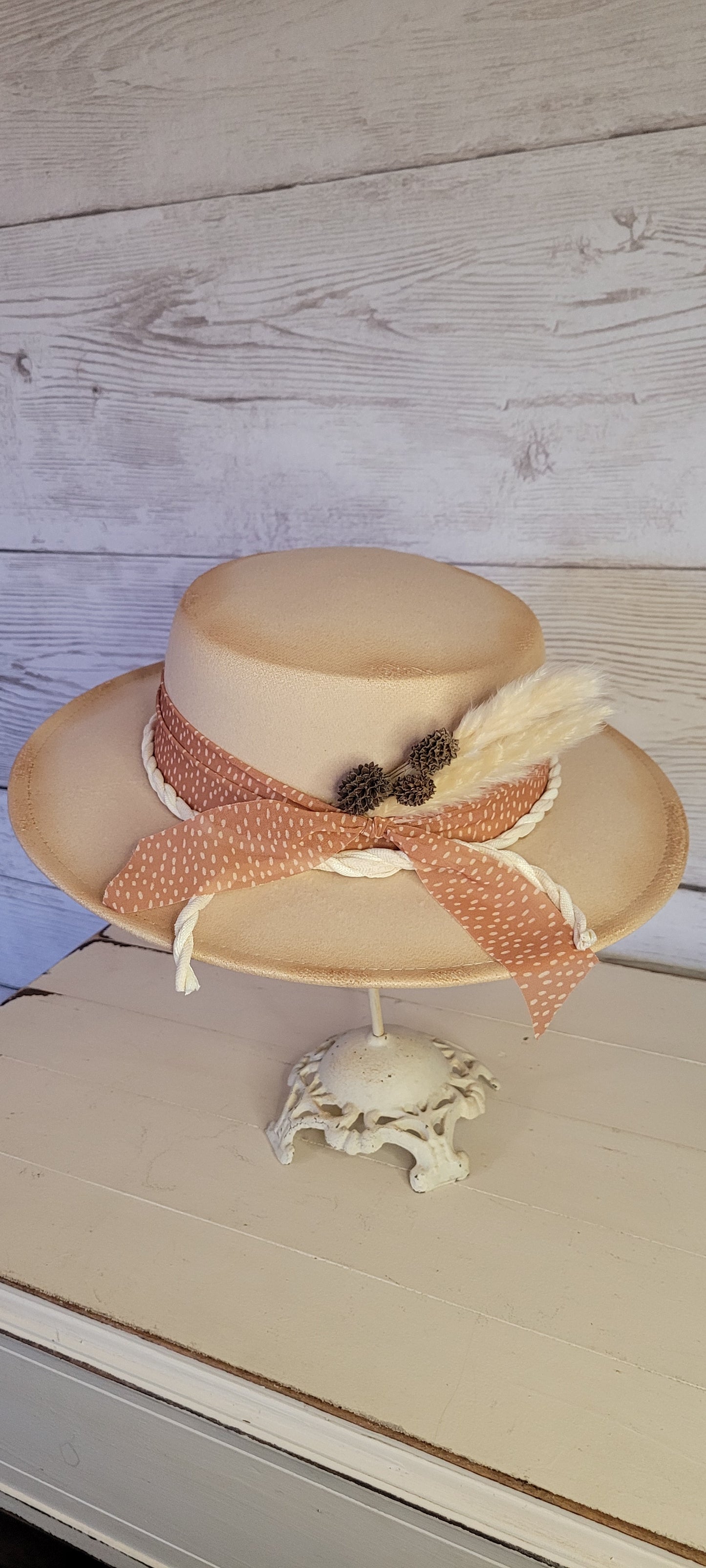 Sheer ribbon, natural gauze rope, pine cones & pampas Felt hat Flat brim 100% polyester Ribbon drawstring for hat size adjustment Head Circumference: 24" Crown Height: 3.5" Brim Length: 13.5" Brim Width: 12.75" Branded & numbered inside crown Custom burned by Kayla