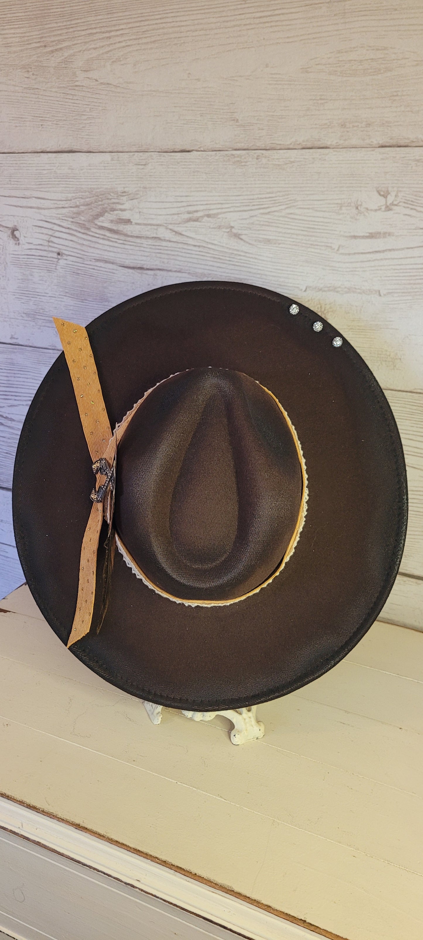 Features natural lace ribbon, corduroy ribbon, feather, playing cards, pistol brooch, & rhinestone beads Felt hat Flat brim 65% polyester and 35% cotton Ribbon drawstring for hat size adjustment Head Circumference: 24" Crown Height: 5" Brim Length: 15.75" Brim Width: 14.5" Branded & numbered inside crown Custom designed by Kayla