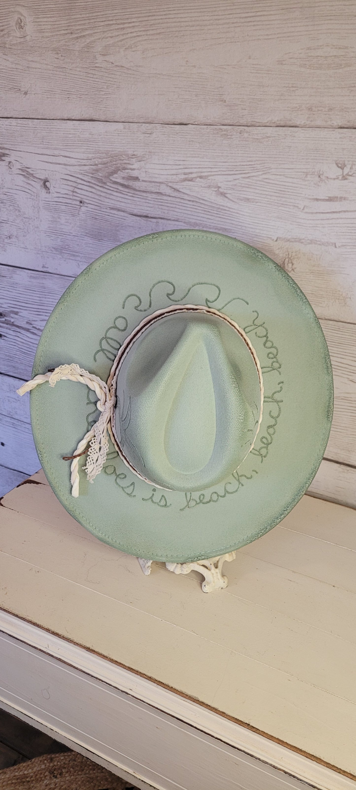 Features sunshine, palm trees, waves & "all she does is beach, beach, beach" engraved Lace ribbon, brown cord, & natural gauze rope Felt hat Flat brim 65% polyester and 35% cotton Ribbon drawstring for hat size adjustment Head Circumference: 24" Crown Height: 5" Brim Length: 15.75" Brim Width: 14.5" Branded & numbered inside crown Custom burned & engraved by Kayla