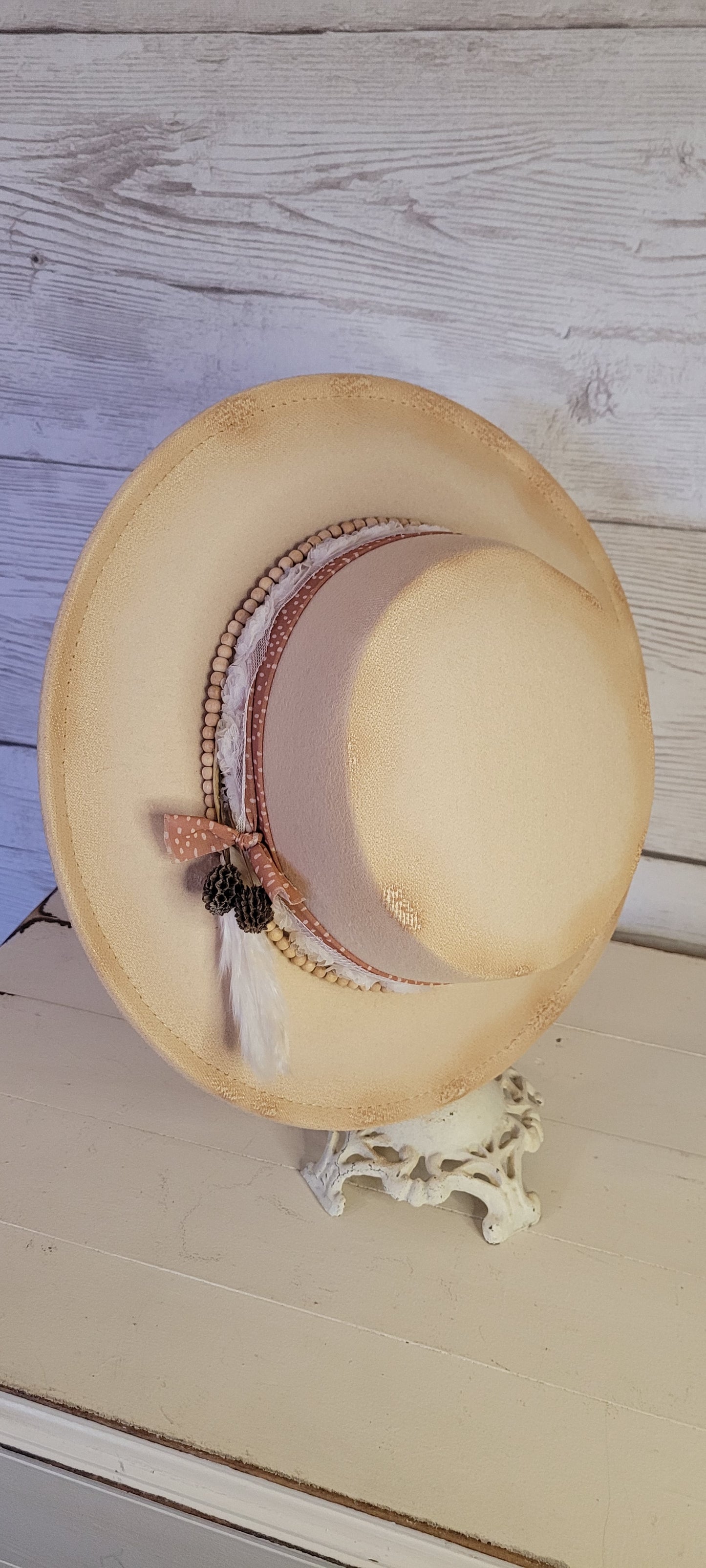 Sheer ribbon, flower ribbon, wooden bead band, pine cones & pampas Felt hat Flat brim 100% polyester Ribbon drawstring for hat size adjustment Head Circumference: 24" Crown Height: 3.5" Brim Length: 13.5" Brim Width: 12.75" Branded & numbered inside crown Custom burned by Kayla