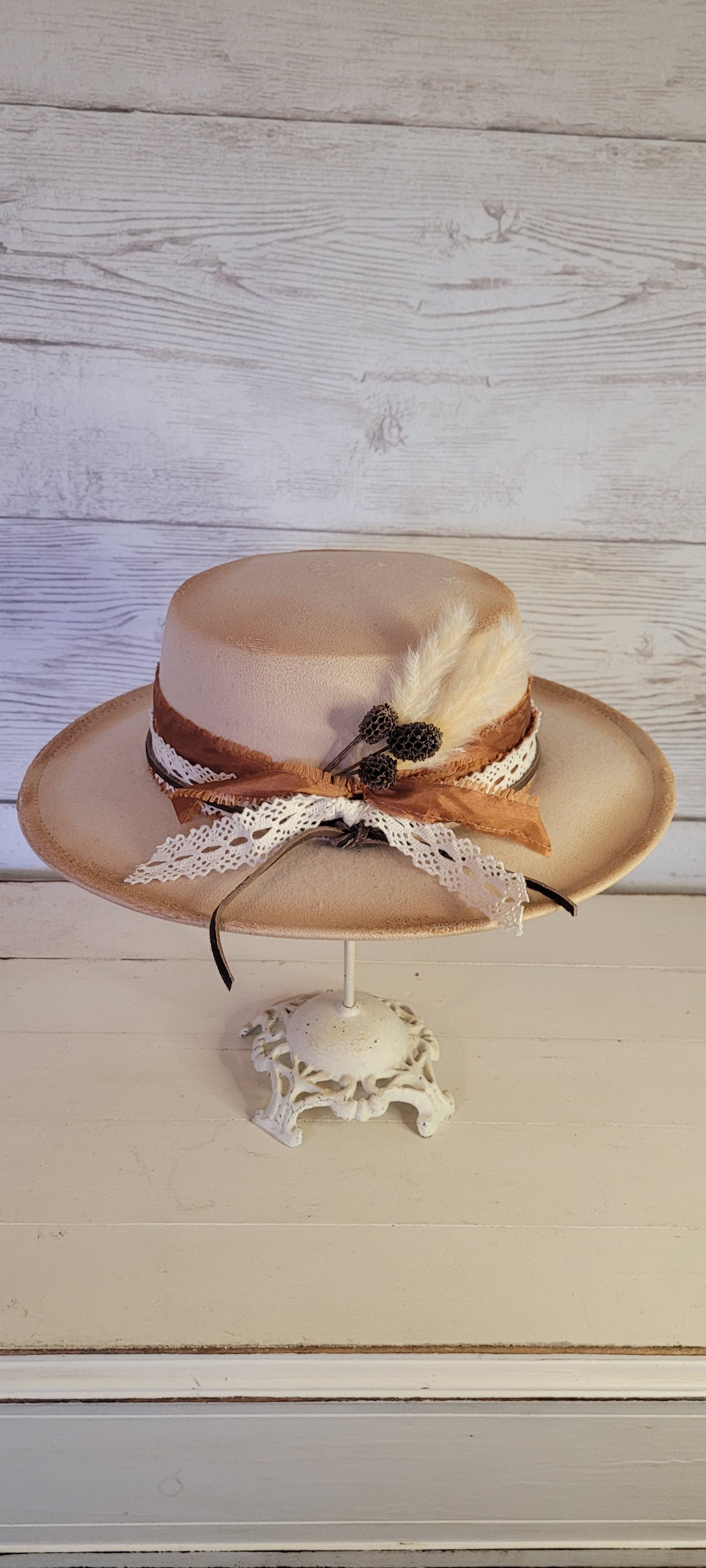 Lace ribbon, frayed lace ribbon, leather band, pampas, pine cones Felt hat Flat brim 100% polyester Ribbon drawstring for hat size adjustment Head Circumference: 24" Crown Height: 3.5" Brim Length: 13.5" Brim Width: 12.75" Branded & numbered inside crown Custom burned & engraved by Kayla