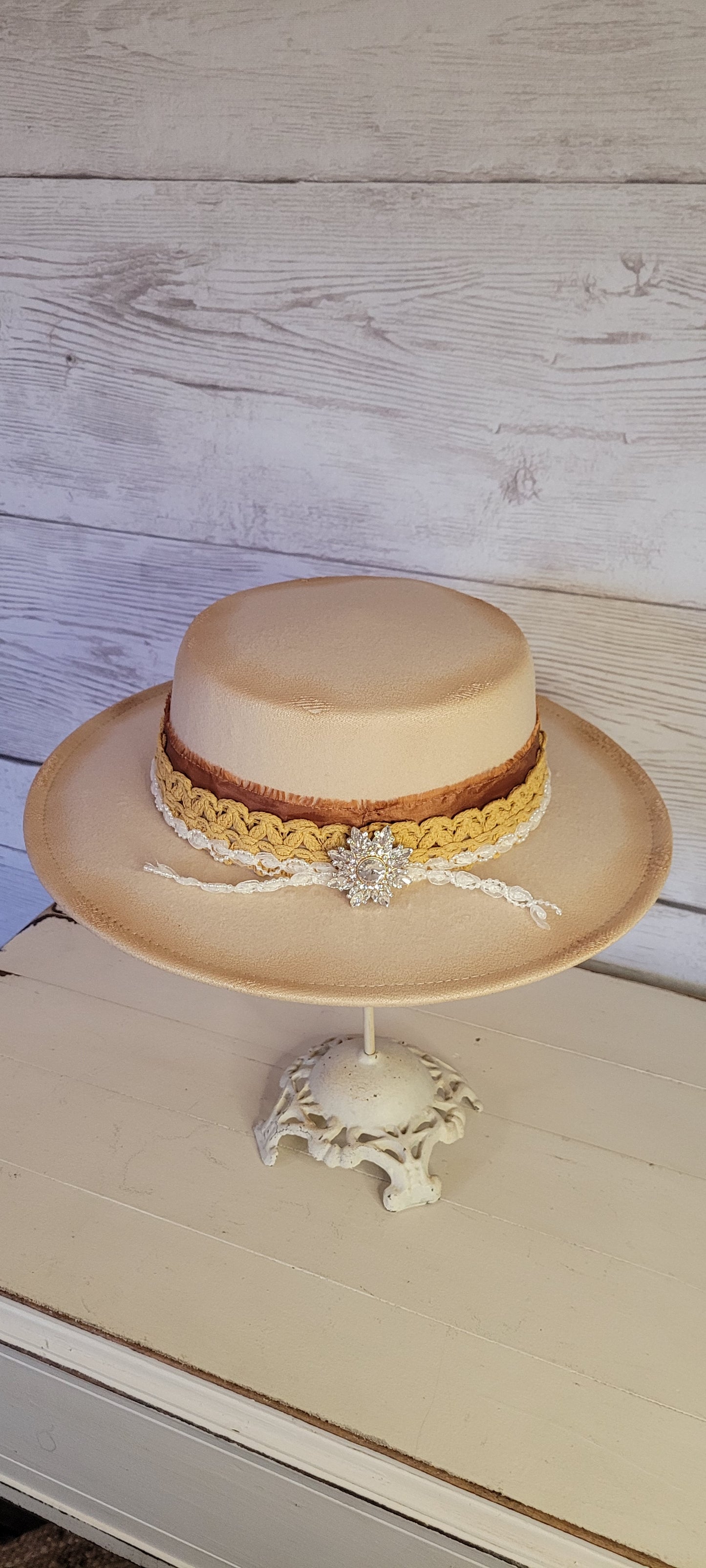 Lace ribbon, frayed lace ribbon, pearl lace ribbon, and rhinestone crystal brooch Felt hat Flat brim 100% polyester Ribbon drawstring for hat size adjustment Head Circumference: 24" Crown Height: 3.5" Brim Length: 13.5" Brim Width: 12.75" Branded & numbered inside crown Custom burned by Kayla
