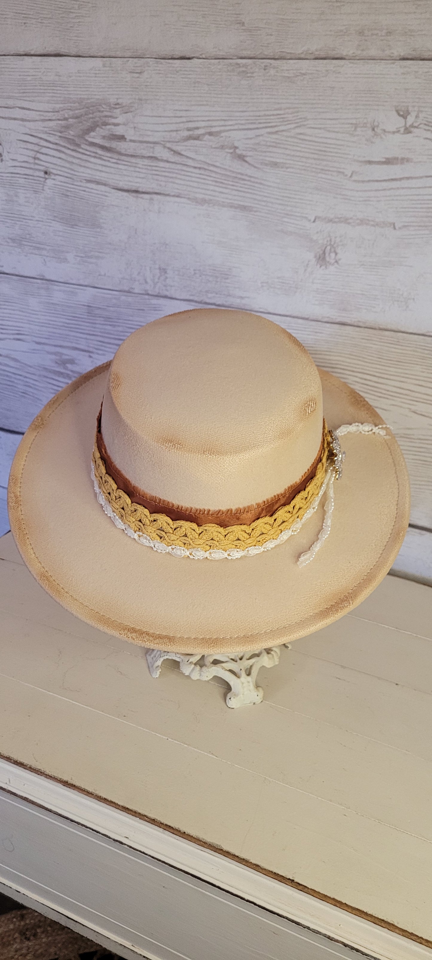 Lace ribbon, frayed lace ribbon, pearl lace ribbon, and rhinestone crystal brooch Felt hat Flat brim 100% polyester Ribbon drawstring for hat size adjustment Head Circumference: 24" Crown Height: 3.5" Brim Length: 13.5" Brim Width: 12.75" Branded & numbered inside crown Custom burned by Kayla