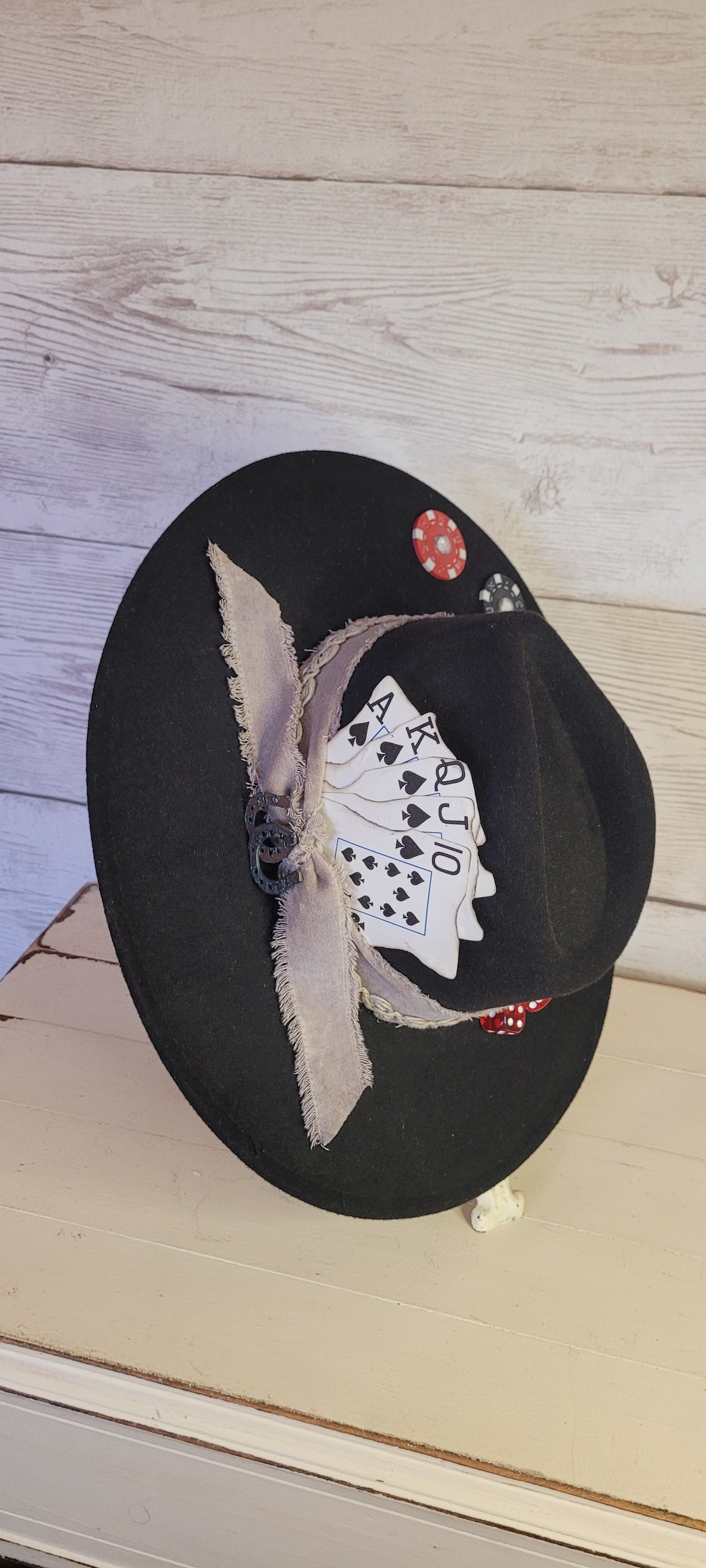 Features poker chips, dice, rhinestones, playing cards, natural frayed & lace ribbon, & metal horseshoe Felt hat Flat brim 35% cotton and 65% polyester Ribbon drawstring for hat size adjustment Head Circumference: 24" Crown Height: 5" Brim Length: 15.75" Brim Width: 14.5" Branded & numbered inside crown Custom designed by Kayla