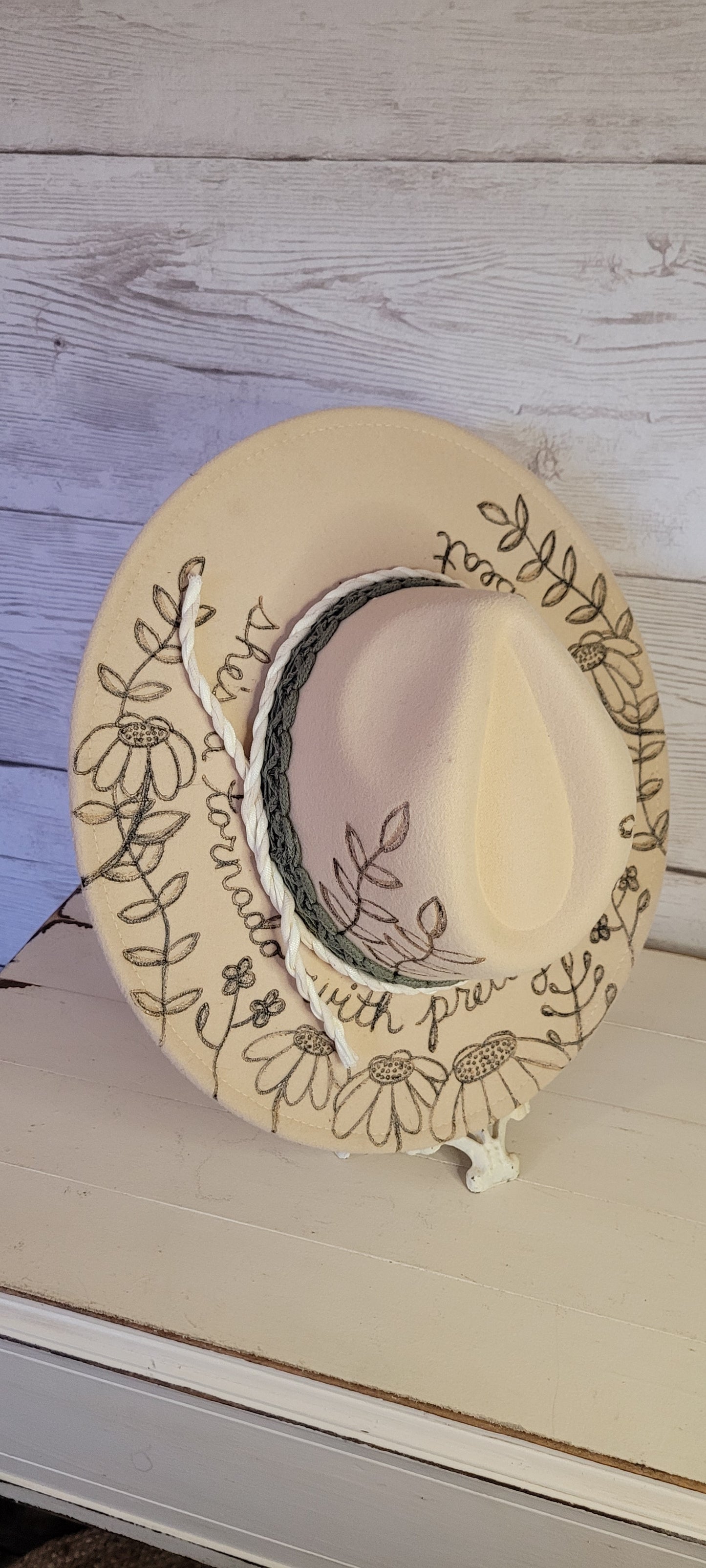 Features engraved whimsical flowers & plants Felt hat Flat brim 65% polyester and 35% cotton Ribbon drawstring for hat size adjustment Head Circumference: 25" H:5.25" L:16" W:14.5" Head Circumference: 24" Crown Height: 5" Brim Length: 15.75" Brim Width: 14.5" Branded & numbered inside crown Custom engraved by Kayla