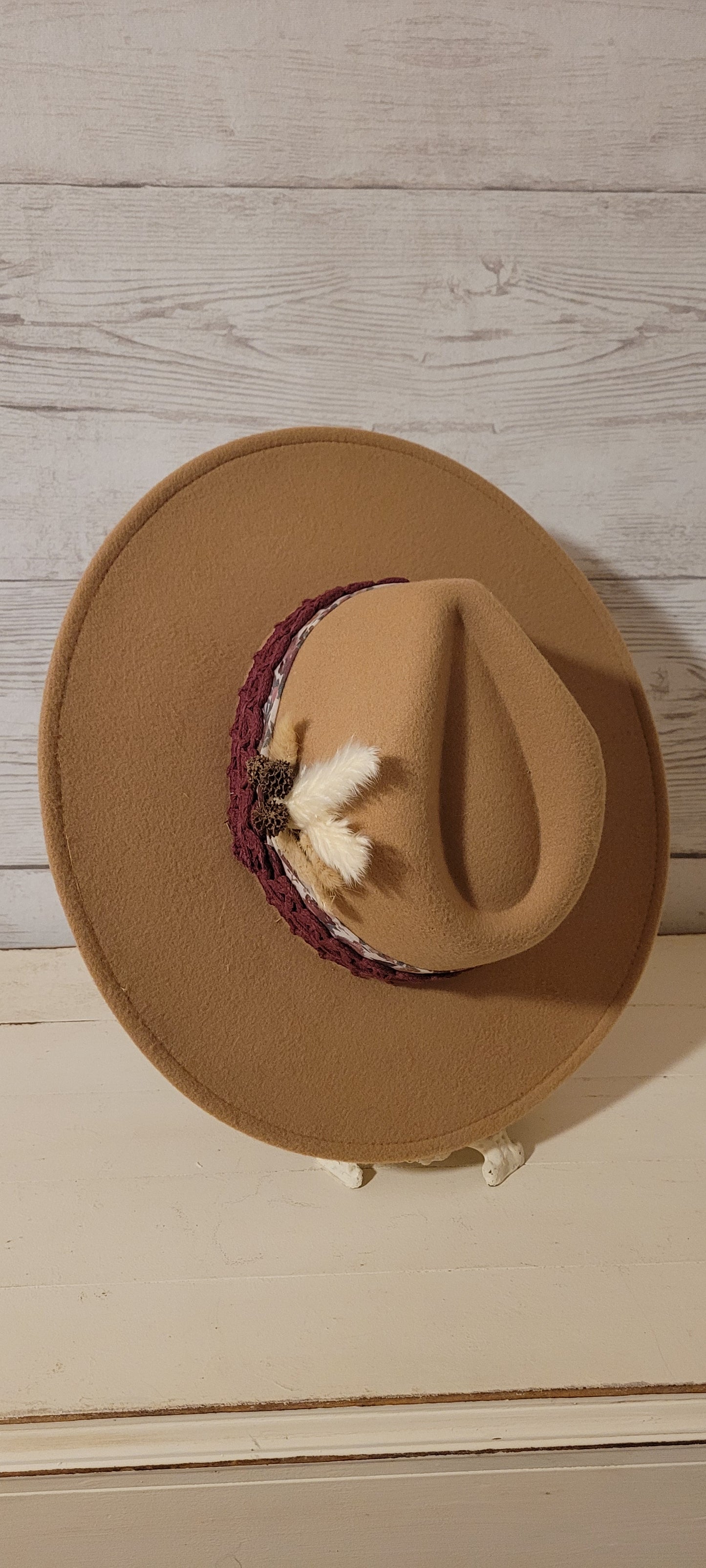 Sheer floral ribbon, lace ribbon, pampas, cattails, pine cones Felt hat Flat brim 100% polyester Ribbon drawstring for hat size adjustment Head Circumference: 24" Crown Height: 5" Brim Length: 15.75" Brim Width: 14.5" Branded & numbered inside crown Custom designed by Kayla