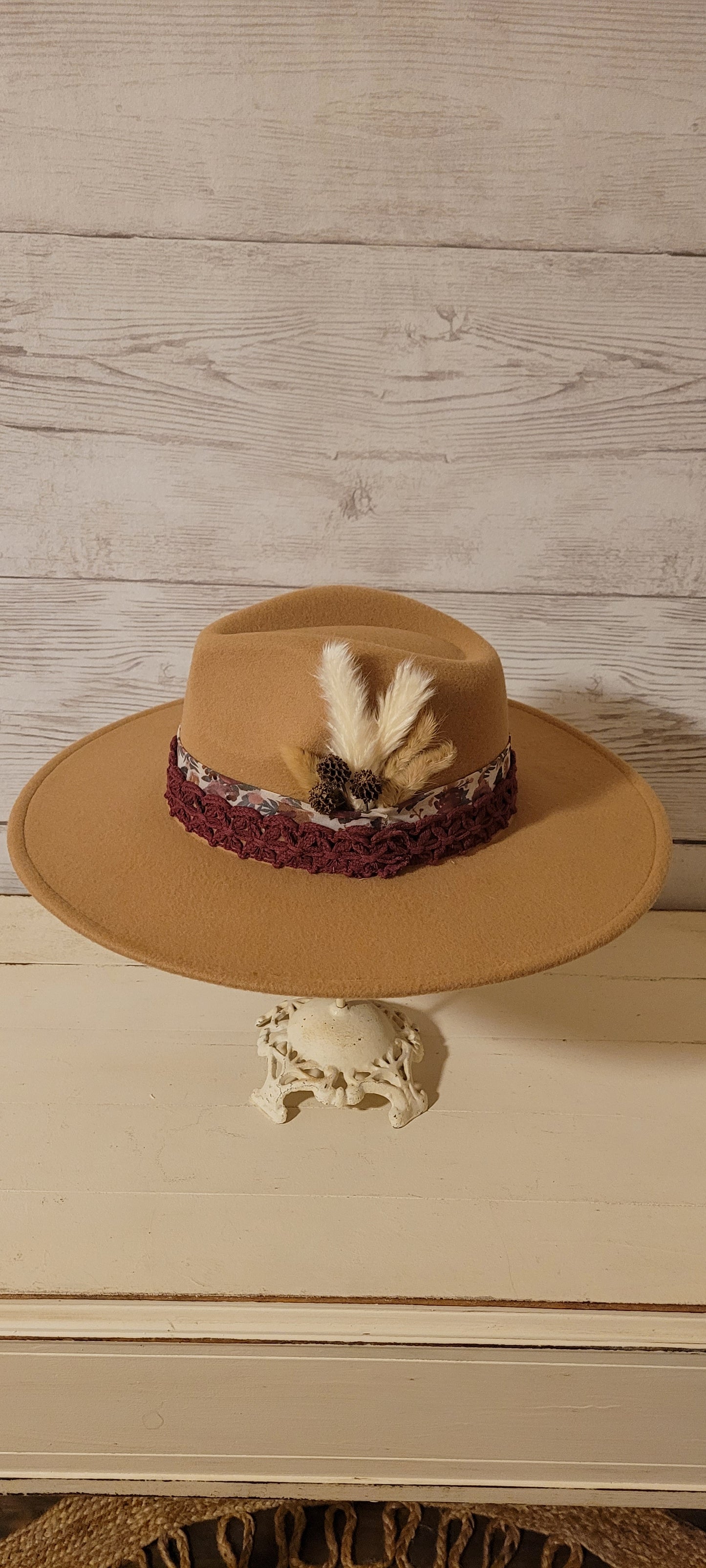 Sheer floral ribbon, lace ribbon, pampas, cattails, pine cones Felt hat Flat brim 100% polyester Ribbon drawstring for hat size adjustment Head Circumference: 24" Crown Height: 5" Brim Length: 15.75" Brim Width: 14.5" Branded & numbered inside crown Custom designed by Kayla