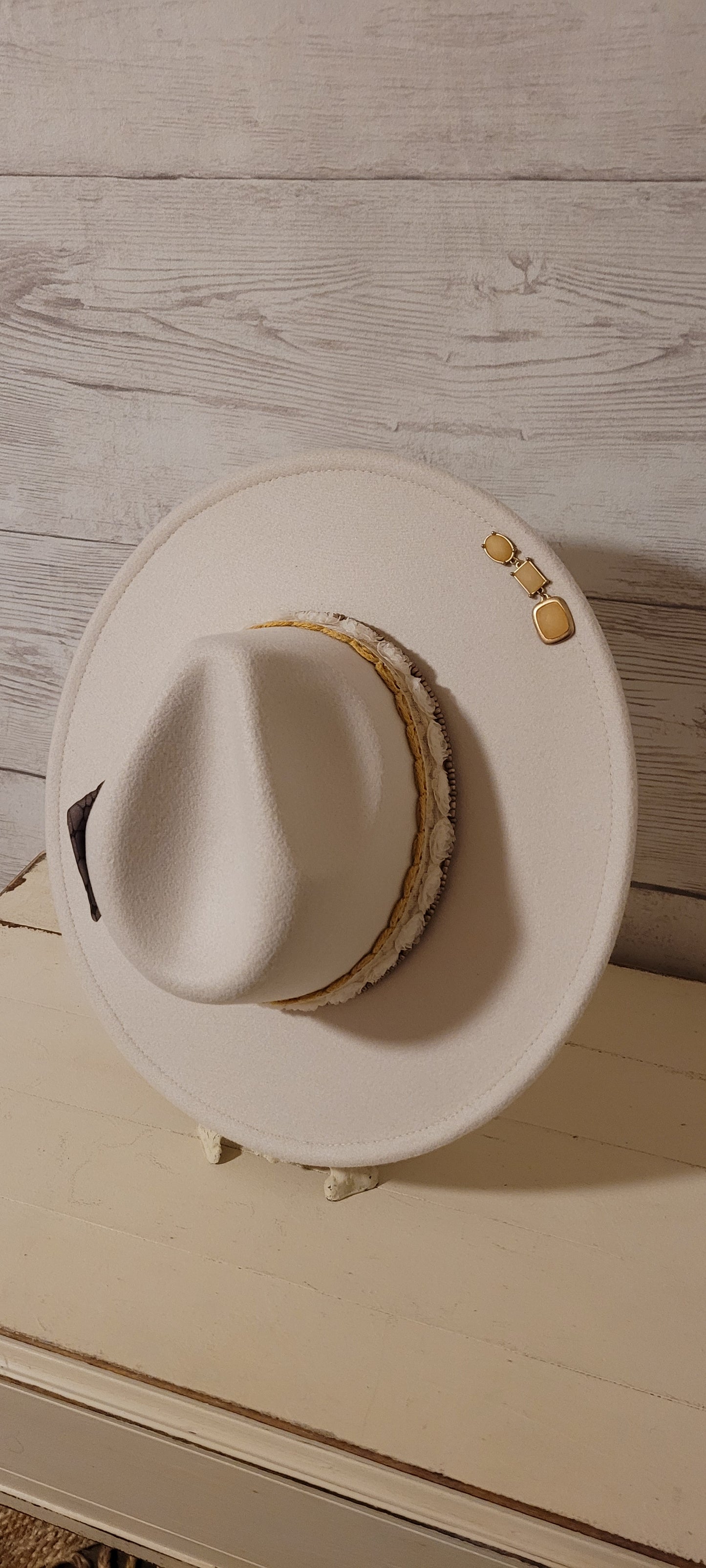 Lace ribbon, sheer floral ribbon, golden seed beads, playing card & rhinestone brooches Felt hat Flat brim 65% polyester and 35% cotton Ribbon drawstring for hat size adjustment Head Circumference: 24" Crown Height: 5" Brim Length: 15.75" Brim Width: 14.5" Branded & numbered inside crown Custom designed by Kayla