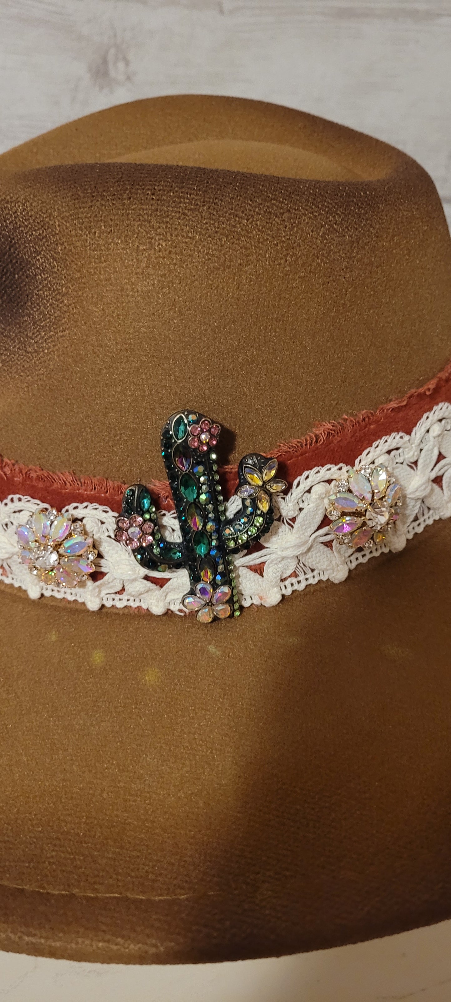 Features "a little hippie. a little gypsy." Natural lace ribbon, frayed velvet ribbon, rhinestone brooches: AB flowers, cactus & arrow Felt hat Flat brim 90% polyester & 10% PU Ribbon drawstring for hat size adjustment Head Circumference: 24" Crown Height: 5" Brim Length: 15.75" Brim Width: 14.5" Branded & numbered inside crown Custom burned & engraved by Kayla