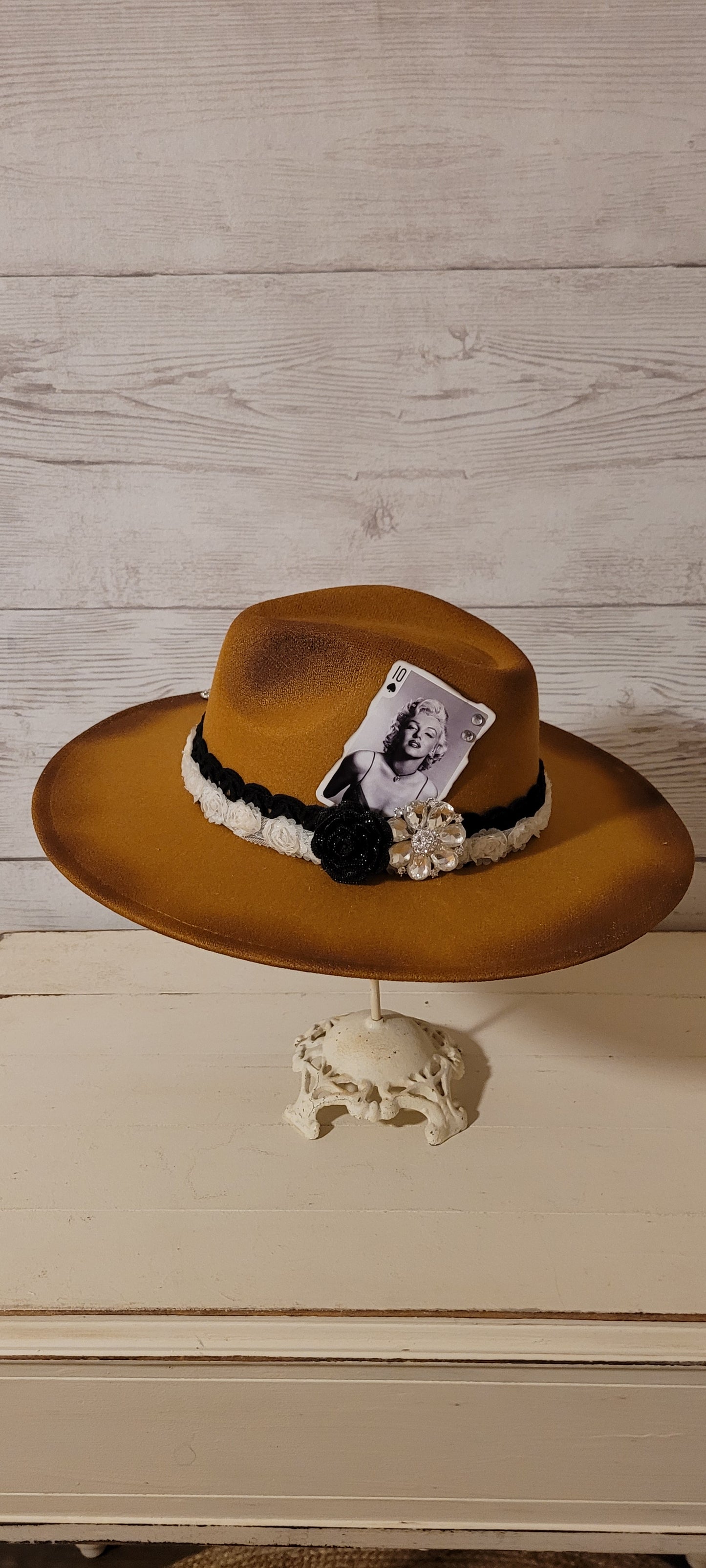 Features black lace ribbon, flower lace ribbon, rhinestone brooches, playing card with rhinestones Felt hat Flat brim 100% polyester Ribbon drawstring for hat size adjustment Head Circumference: 24" Crown Height: 5" Brim Length: 15.75" Brim Width: 14.5" Branded & numbered inside crown Custom burned & engraved by Kayla