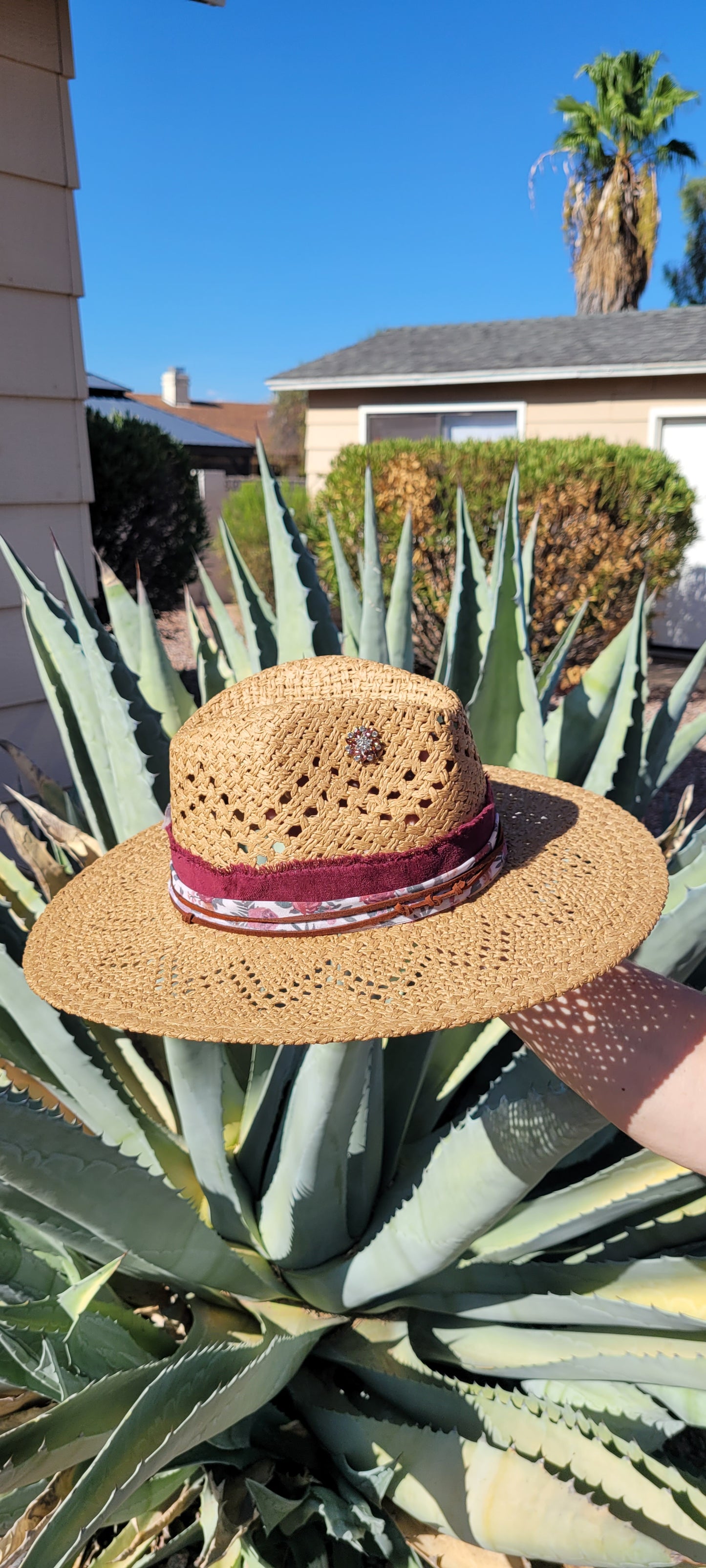 Features frayed velvet ribbon, sheer floral ribbon, suede band, saguaro cactus & flower brooches Straw hat Flat brim 65% polyester and 35% cotton Ribbon drawstring for hat size adjustment Head Circumference: 24" Crown Height: 5" Brim Length: 15.75" Brim Width: 14.75" Branded & numbered inside crown Custom designed by Kayla