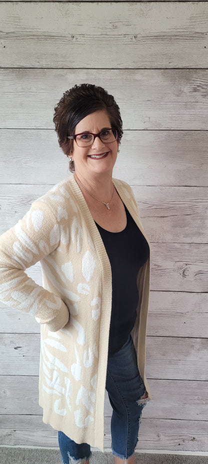 Snuggle up and stay warm in this very soft Dylan beige and ivory animal print cardigan! Flaunt your wild side and show off the cozy vibes in the most stylish way. (It's the purr-fect layering piece!) Sizes small through large.