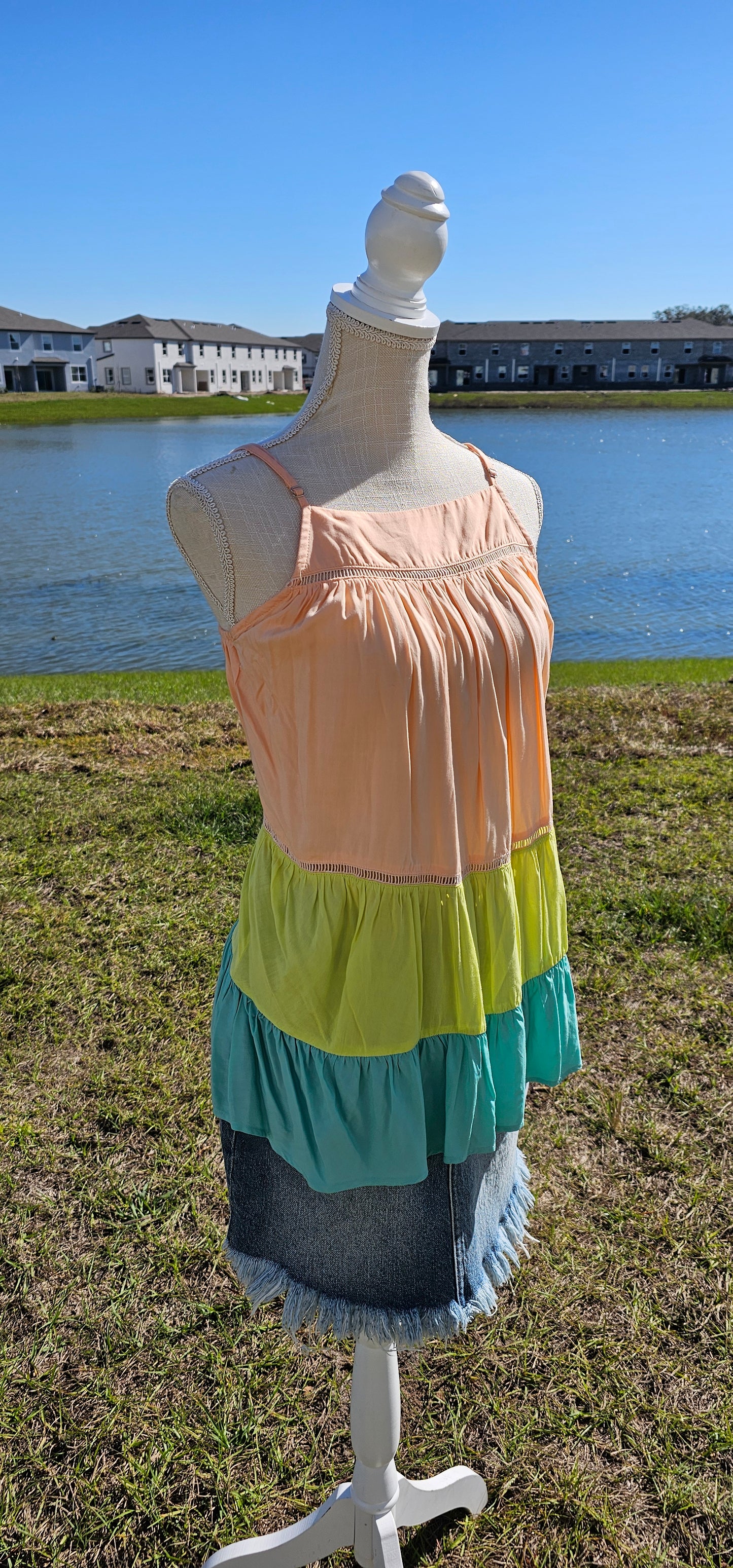 “Tutti Frutti” is a vibrant color block tank top. This tank top features three tiers of color (sherbet orange, lime green, light teal), adjustable straps, elastic back, pleated flare top and cute peekaboo lace trim. This top does not have stretch, but is loose fitting and longer in length. It is super lightweight and breathable. Sizes small through large.