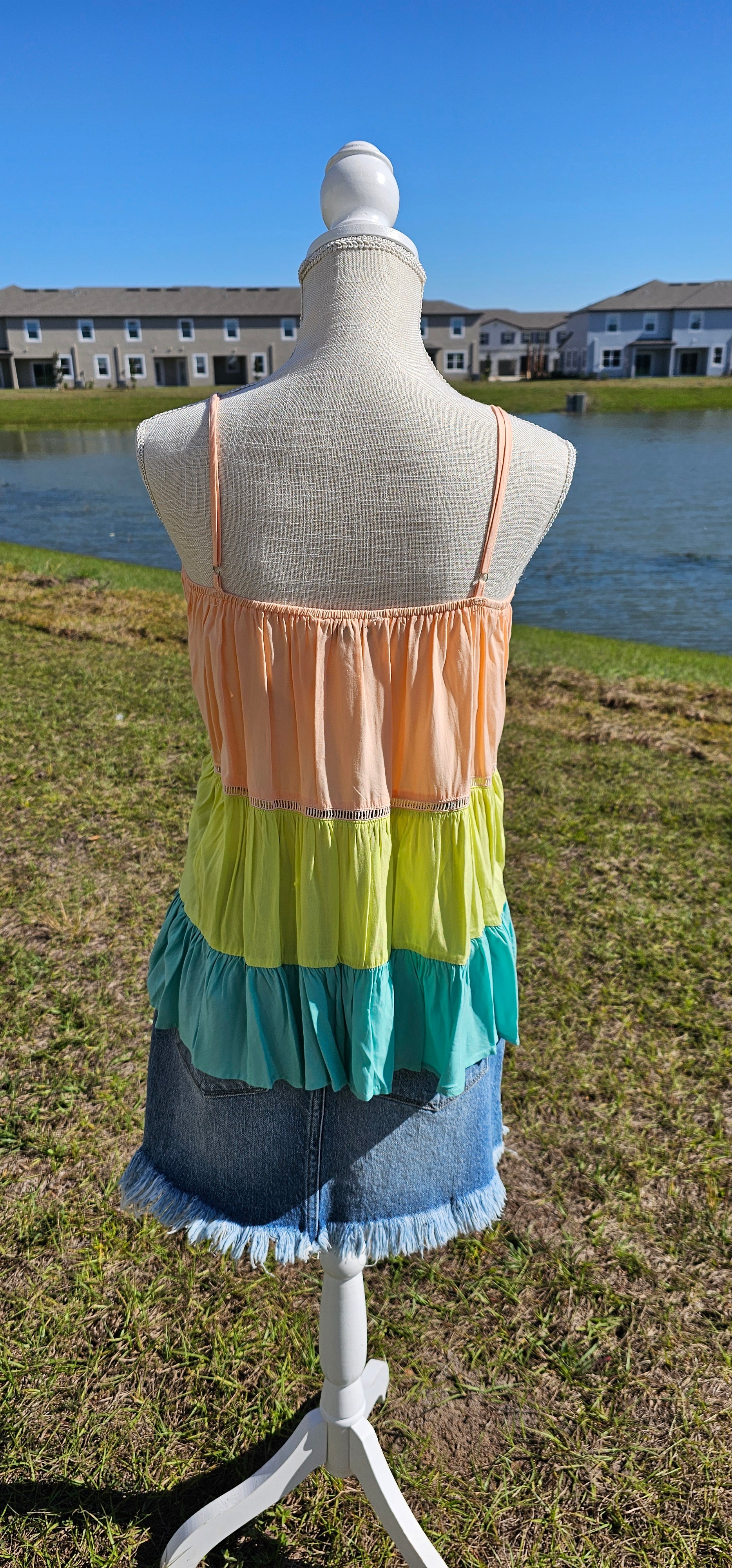 “Tutti Frutti” is a vibrant color block tank top. This tank top features three tiers of color (sherbet orange, lime green, light teal), adjustable straps, elastic back, pleated flare top and cute peekaboo lace trim. This top does not have stretch, but is loose fitting and longer in length. It is super lightweight and breathable. Sizes small through large.