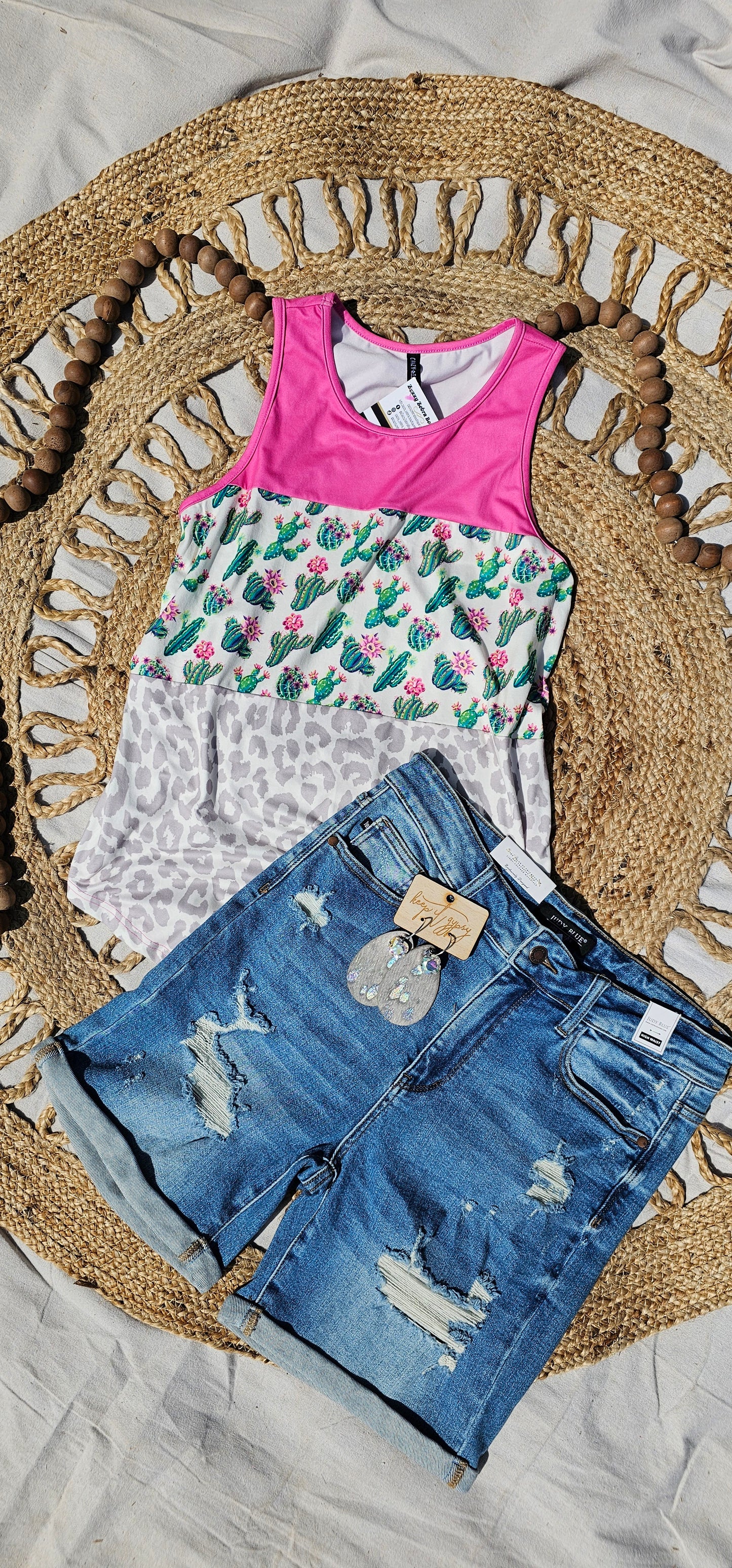 “Don’t Be A Prick” top is a sleeveless tank top, featuring a fuchsia, cactus print, and gray leopard block pattern. It has a solid fuchsia back, scoop neckline, and rounded hemline. This top is buttery soft and has stretch. What a cute summer top! Sizes small through large.