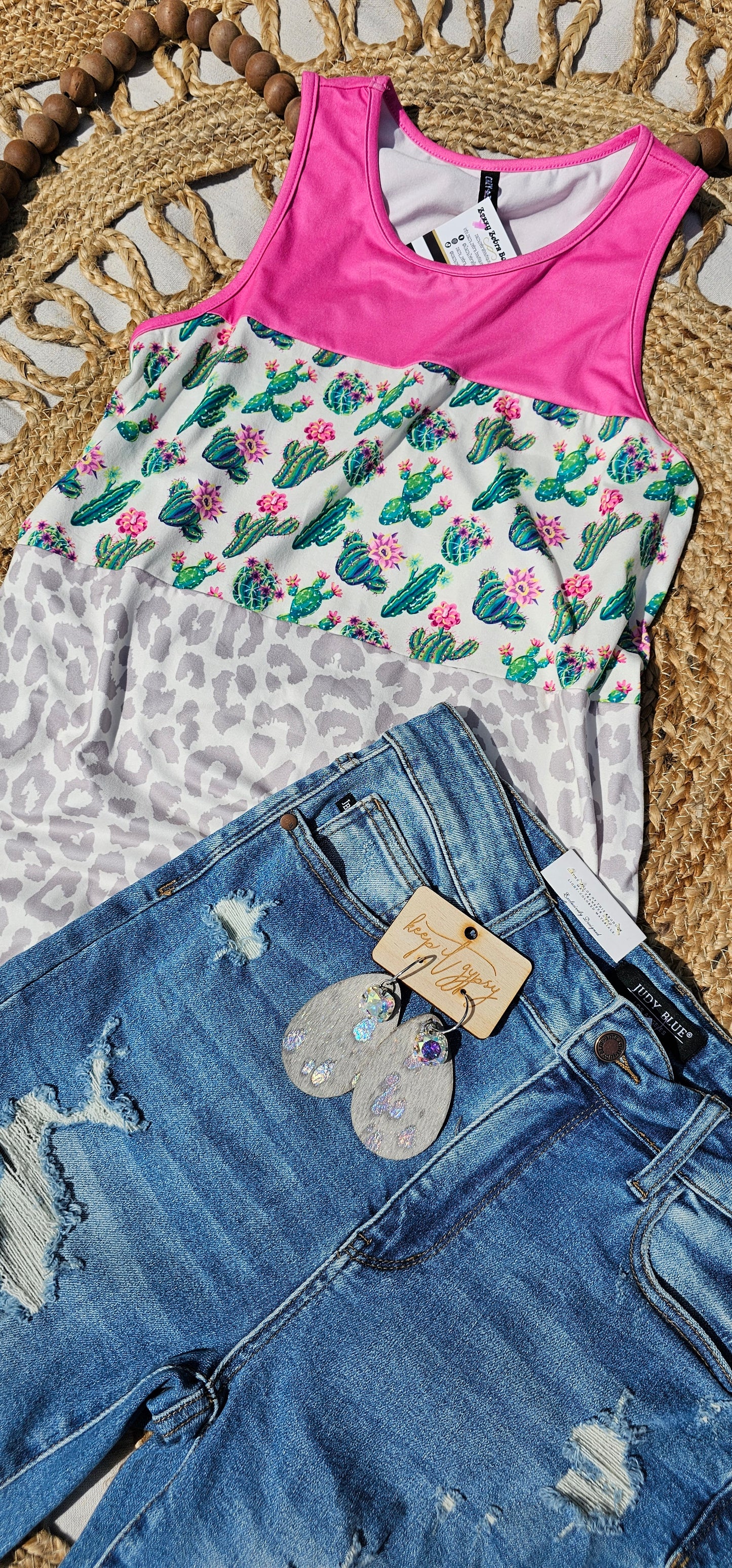 “Don’t Be A Prick” top is a sleeveless tank top, featuring a fuchsia, cactus print, and gray leopard block pattern. It has a solid fuchsia back, scoop neckline, and rounded hemline. This top is buttery soft and has stretch. What a cute summer top! Sizes small through large.