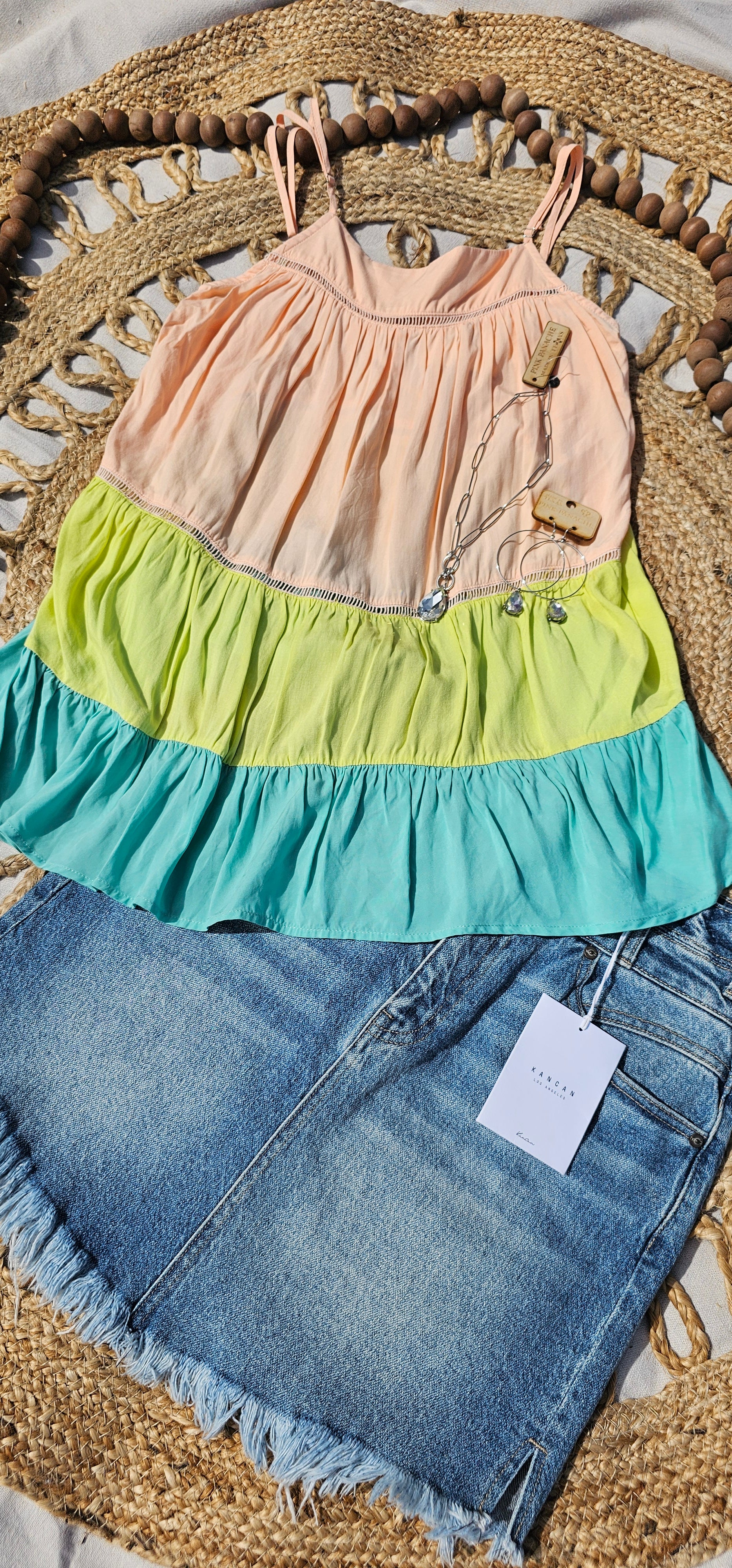 “Tutti Frutti” is a vibrant color block tank top. This tank top features three tiers of color (sherbet orange, lime green, light teal), adjustable straps, elastic back, pleated flare top and cute peekaboo lace trim. This top does not have stretch, but is loose fitting and longer in length. It is super lightweight and breathable. Sizes small through large.
