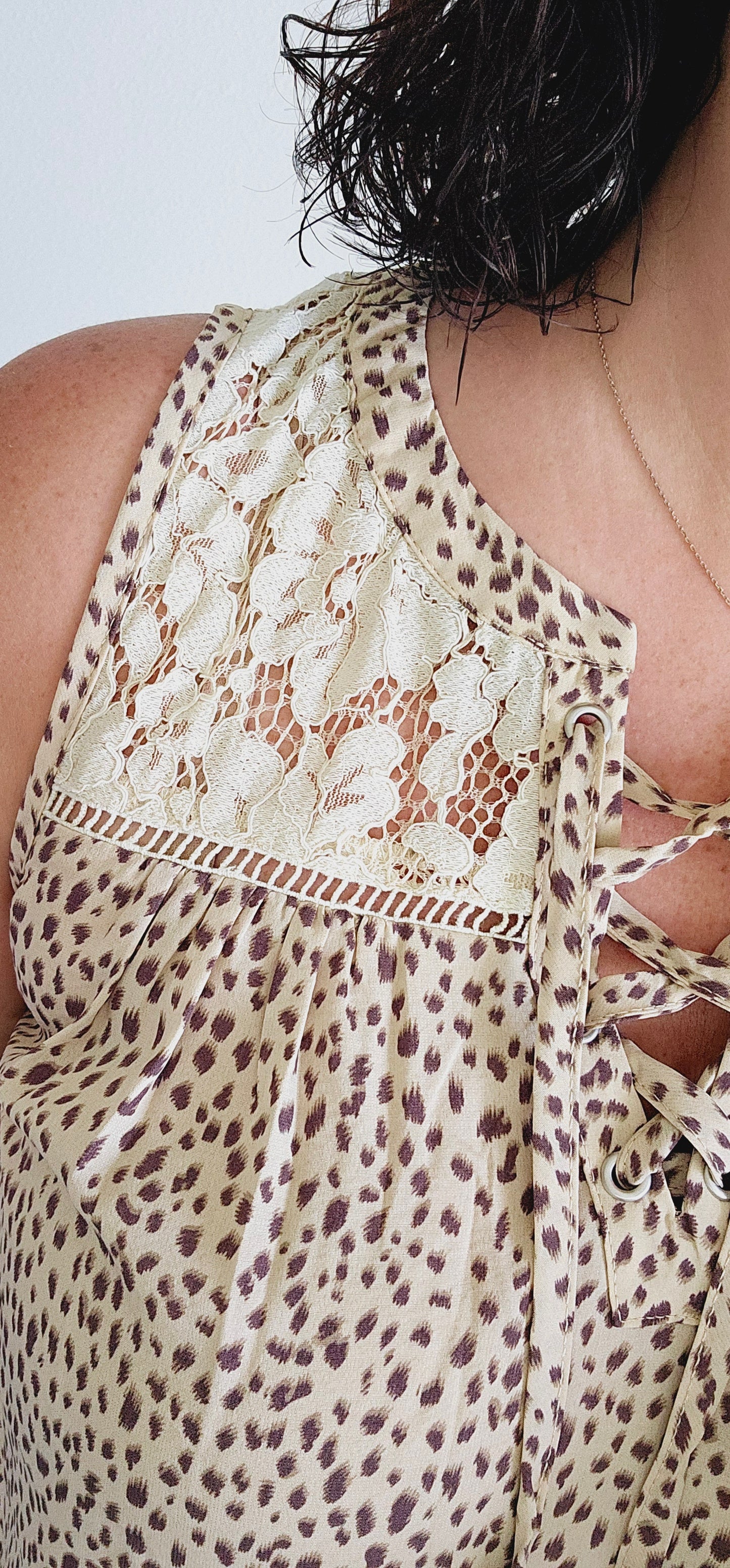 Unleash your wild side in this sleeveless top! This fierce top features a playful leopard print and a delicate lace yoke for a touch of elegance. With a sexy lace-up v-neck, you'll be turning heads wherever you go. Roar with style in beige! Sizes small through large.