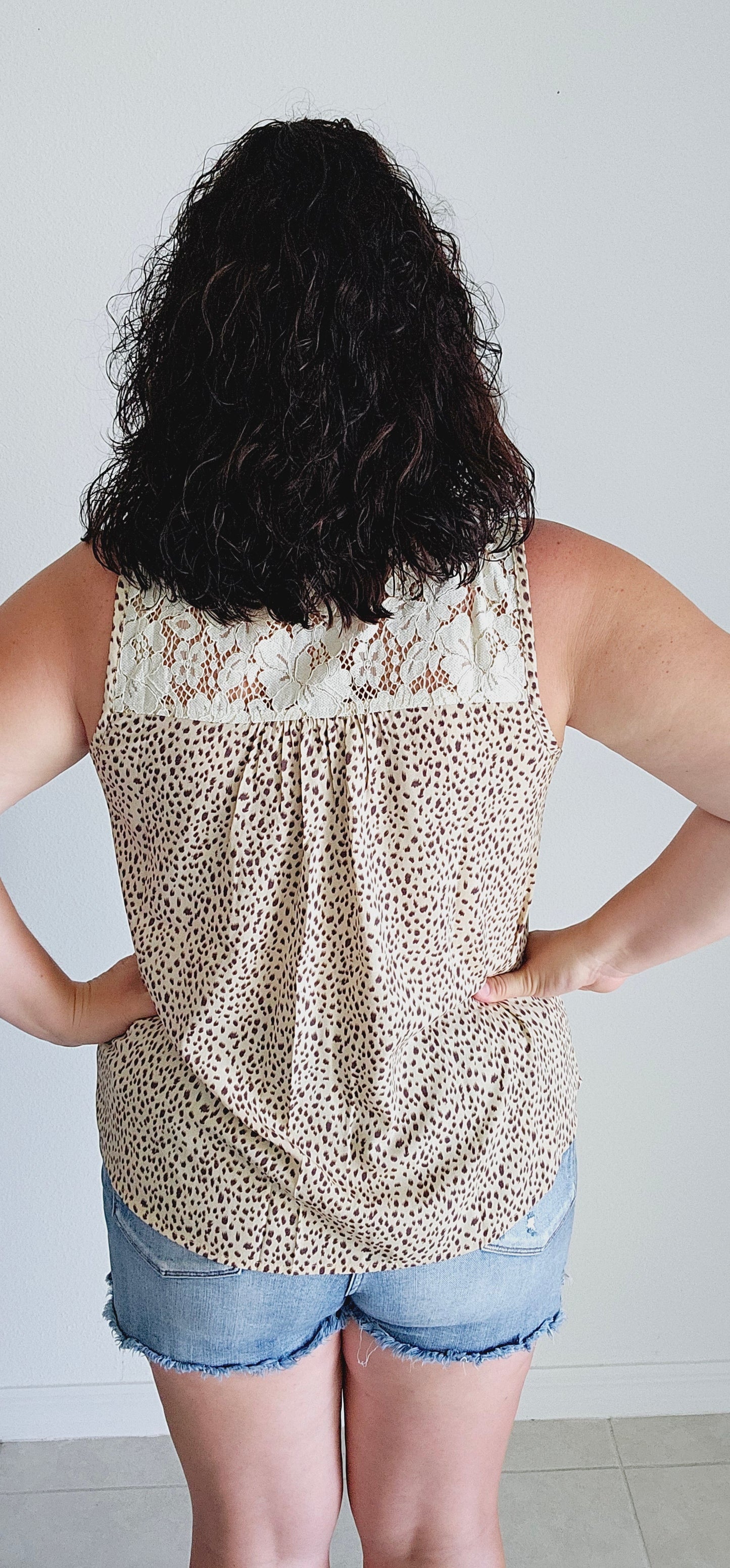 Unleash your wild side in this sleeveless top! This fierce top features a playful leopard print and a delicate lace yoke for a touch of elegance. With a sexy lace-up v-neck, you'll be turning heads wherever you go. Roar with style in beige! Sizes small through large.