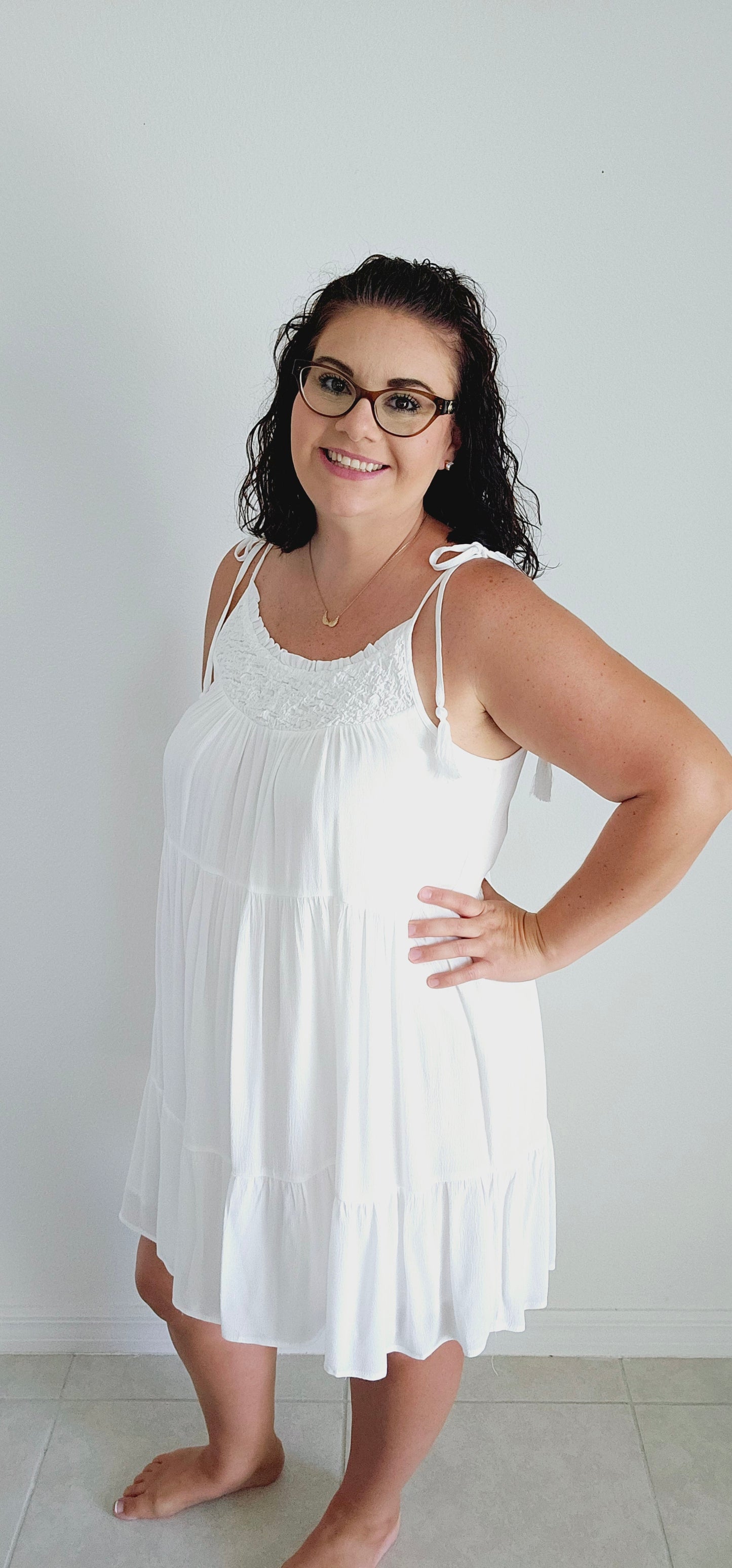 Get ready to make a statement with this flirty mini dress. Featuring a unique popcorn smocking chest and playful tassel detail straps, this dress is perfect for those vacation vibes. The tiered mini length adds a touch of fun and flirty to your look. Bring on the sun! Sizes small through large.