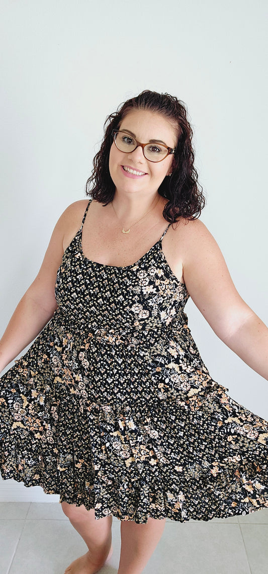 Dress to impress in this mini dress! With a playful floral pattern, adjustable spaghetti straps, and a tie back, this dress is perfect for any occasion. The tiered ruffles add a touch of whimsy to your look. Sizes small through large.