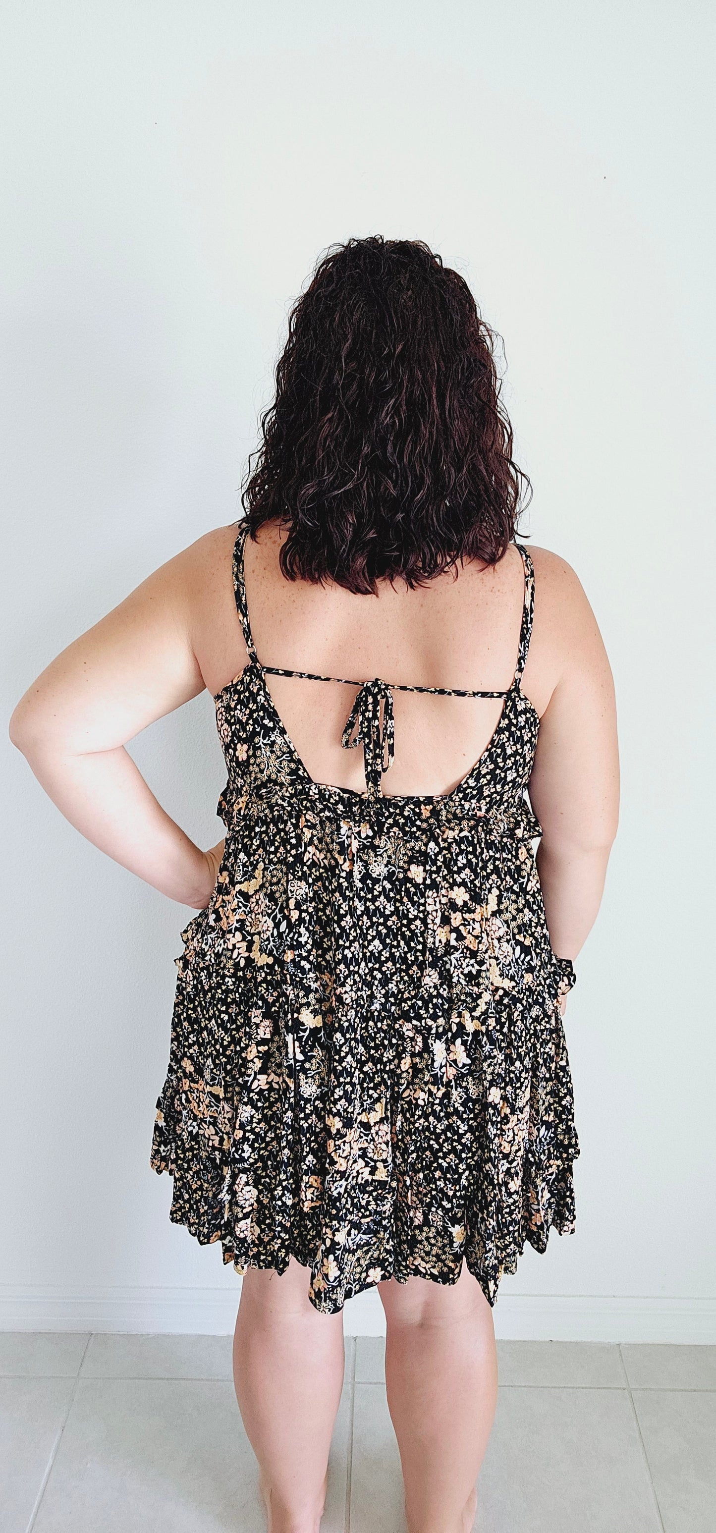 Dress to impress in this mini dress! With a playful floral pattern, adjustable spaghetti straps, and a tie back, this dress is perfect for any occasion. The tiered ruffles add a touch of whimsy to your look. Sizes small through large.