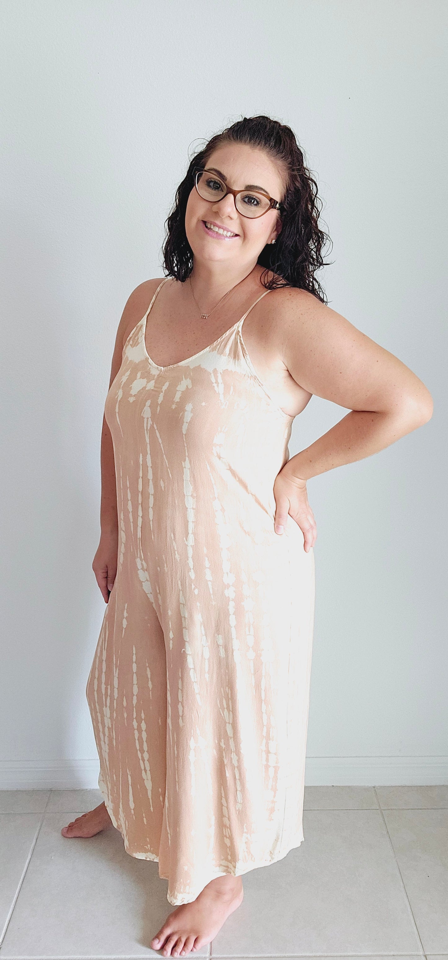 Unleash your inner boho queen with the Taylor Tie Dye Spaghetti Strap Jumpsuit! This unique jumpsuit features a playful tie-dye print and a flattering cropped wide leg. The sleeveless V-neck and adjustable shoulder straps make for comfortable and stylish wear. Perfect for music festivals or a casual day out. Sizes small through large.