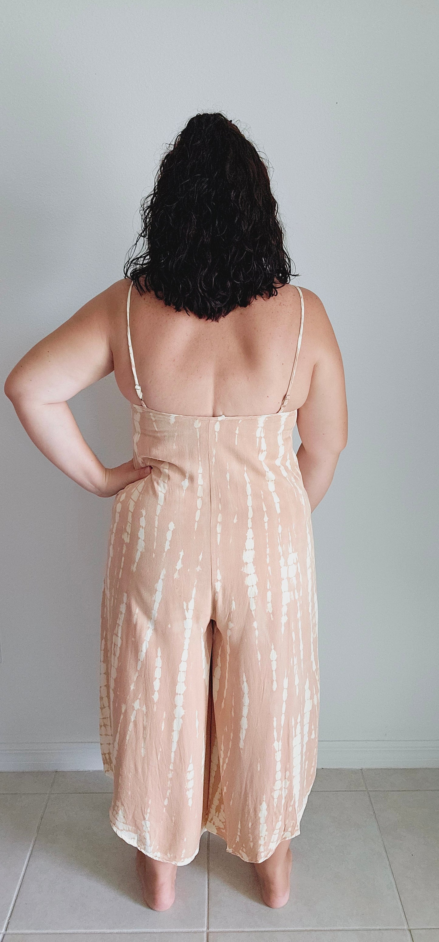 Unleash your inner boho queen with the Taylor Tie Dye Spaghetti Strap Jumpsuit! This unique jumpsuit features a playful tie-dye print and a flattering cropped wide leg. The sleeveless V-neck and adjustable shoulder straps make for comfortable and stylish wear. Perfect for music festivals or a casual day out. Sizes small through large.
