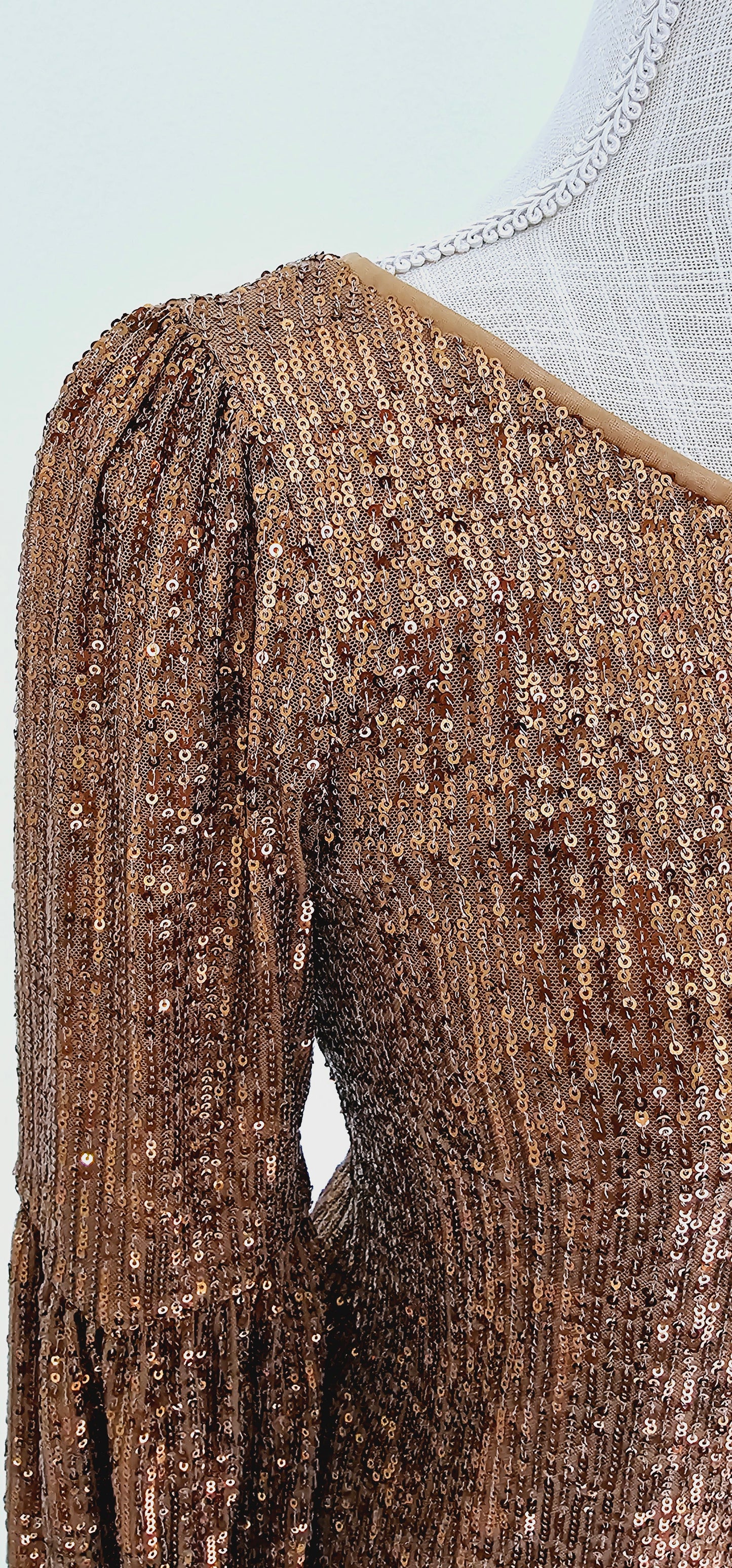 This gold sequined one shoulder top features a long puff sleeve, lining throughout, and side zipper with clasp. Pair with your favorite skirt or dress pants. Don’t be afraid to get creative! Sizes small through large.