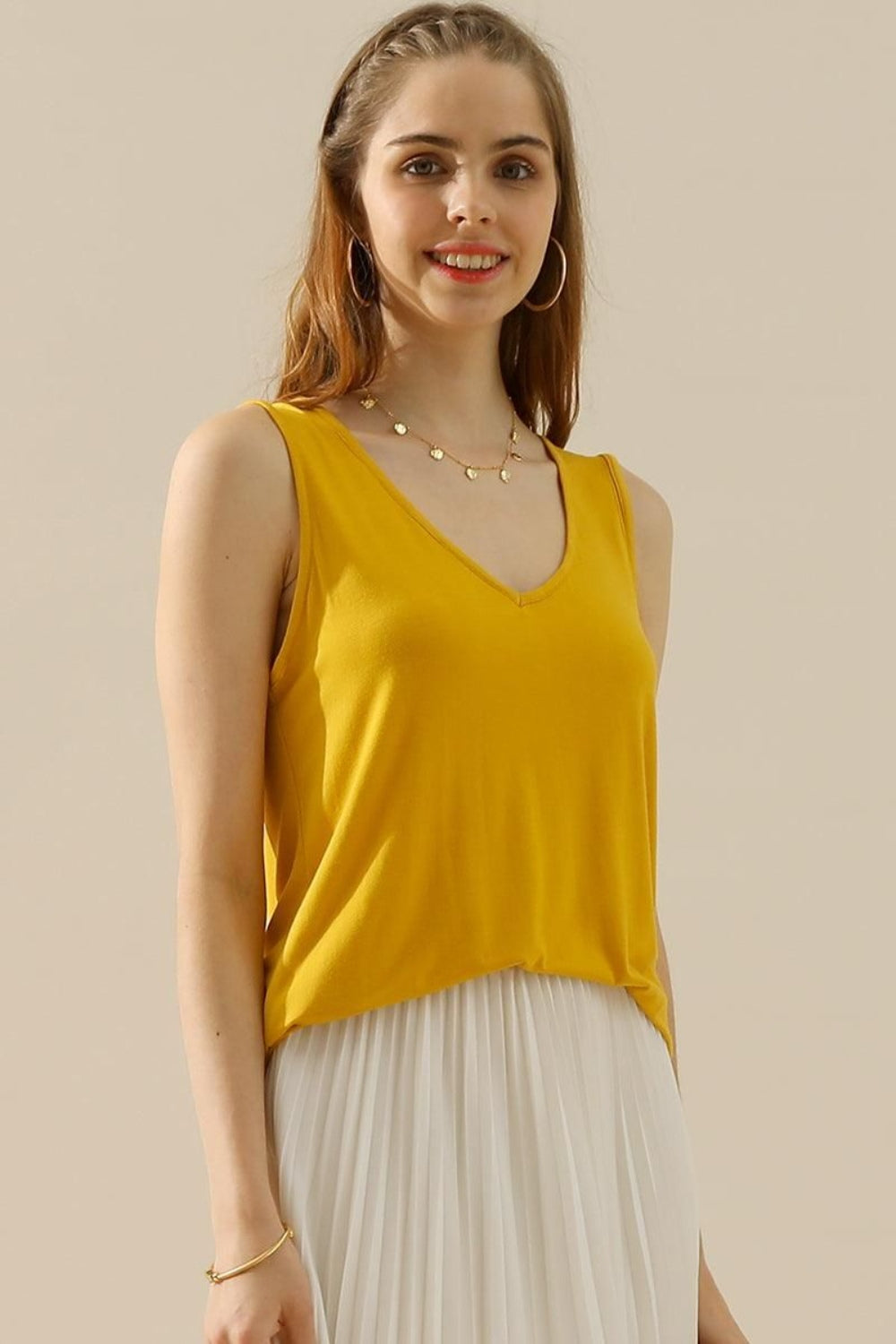 The V-Neck Curved Hem Tank is a stylish and versatile piece. With its flattering neckline and curved hem, it adds a touch of femininity to any outfit. The tank's relaxed fit provides comfort without sacrificing style. S - XL