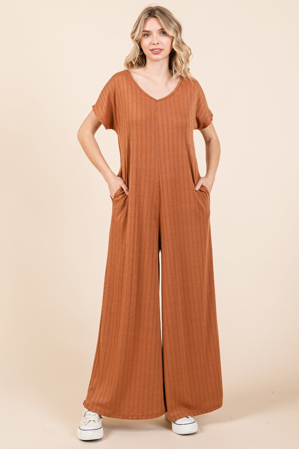 The Ribbed Short Sleeve Wide Leg Jumpsuit is a trendy and versatile fashion piece that offers both style and comfort. With a ribbed texture and wide-leg silhouette, this jumpsuit combines a chic look with a relaxed fit. The short sleeves add a casual touch, making it suitable for various occasions.  S-XL