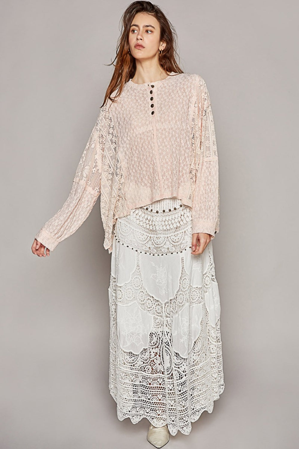 The round neck top with placket, straight sleeves, and a relaxed fit in acrylic sweater material is a cozy and stylish choice for cooler weather. The outseam edge detail and pointed solid pattern add a modern twist to the design, creating a chic and sophisticated look. S-L