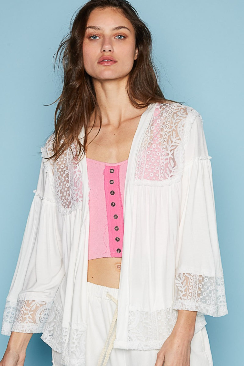 The designed open front oversized fit cardigan with 3/4 length bell sleeves is a chic layering piece for any outfit. Crafted from a mix of jersey and lace, this cardigan combines comfort with a touch of elegance. The frayed edge detail on the entire garment adds a contemporary and edgy vibe, giving it a unique and textured look. S-L