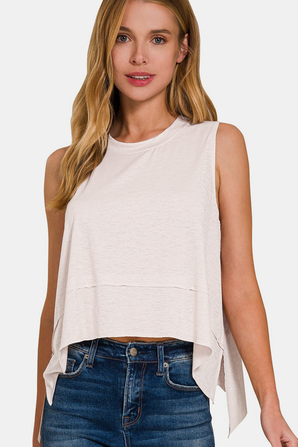 The Slit High-Low Round Neck Tank is a chic and trendy top that adds a touch of sophistication to any outfit. Featuring a stylish high-low hem with side slits, this tank offers a modern twist on a classic silhouette. The round neck design creates a flattering neckline, while the sleeveless style is perfect for warm weather or layering under a cardigan or jacket.  S-L
