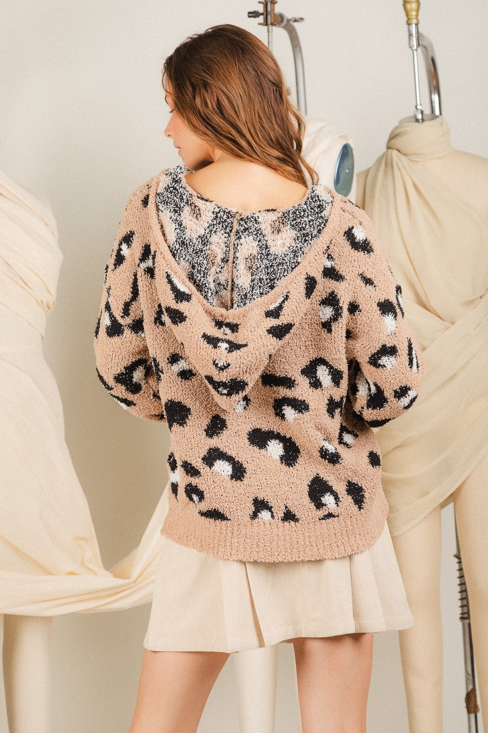 This is a long sleeve, v-neck, hooded popcorn sweater with animal print. Sizes small through large.