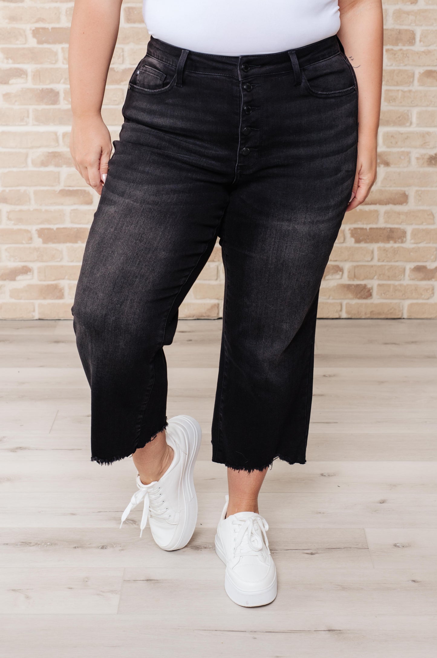 Get ready to rock stylishly with Ryan High Rise Jeans! These wide leg crop jeans feature a coordinating button fly and a washed out black garment dye for a cool, edgy look. With a high rise and raw hem, you'll stand out in the best way possible. 0-24W